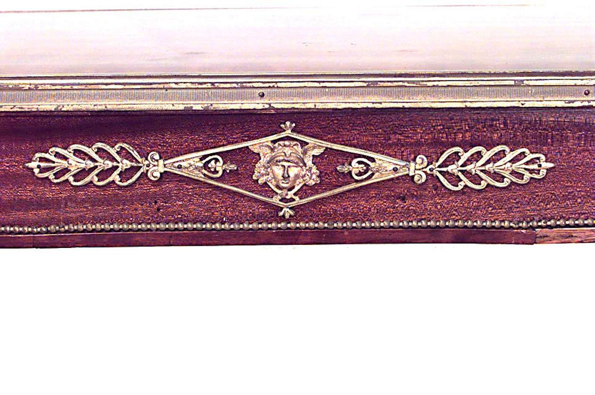 Mesa escritorio francesa de caoba estilo Luis XVI (s. XIX) con cabezas de carnero de bronce y adornos con camilla.
