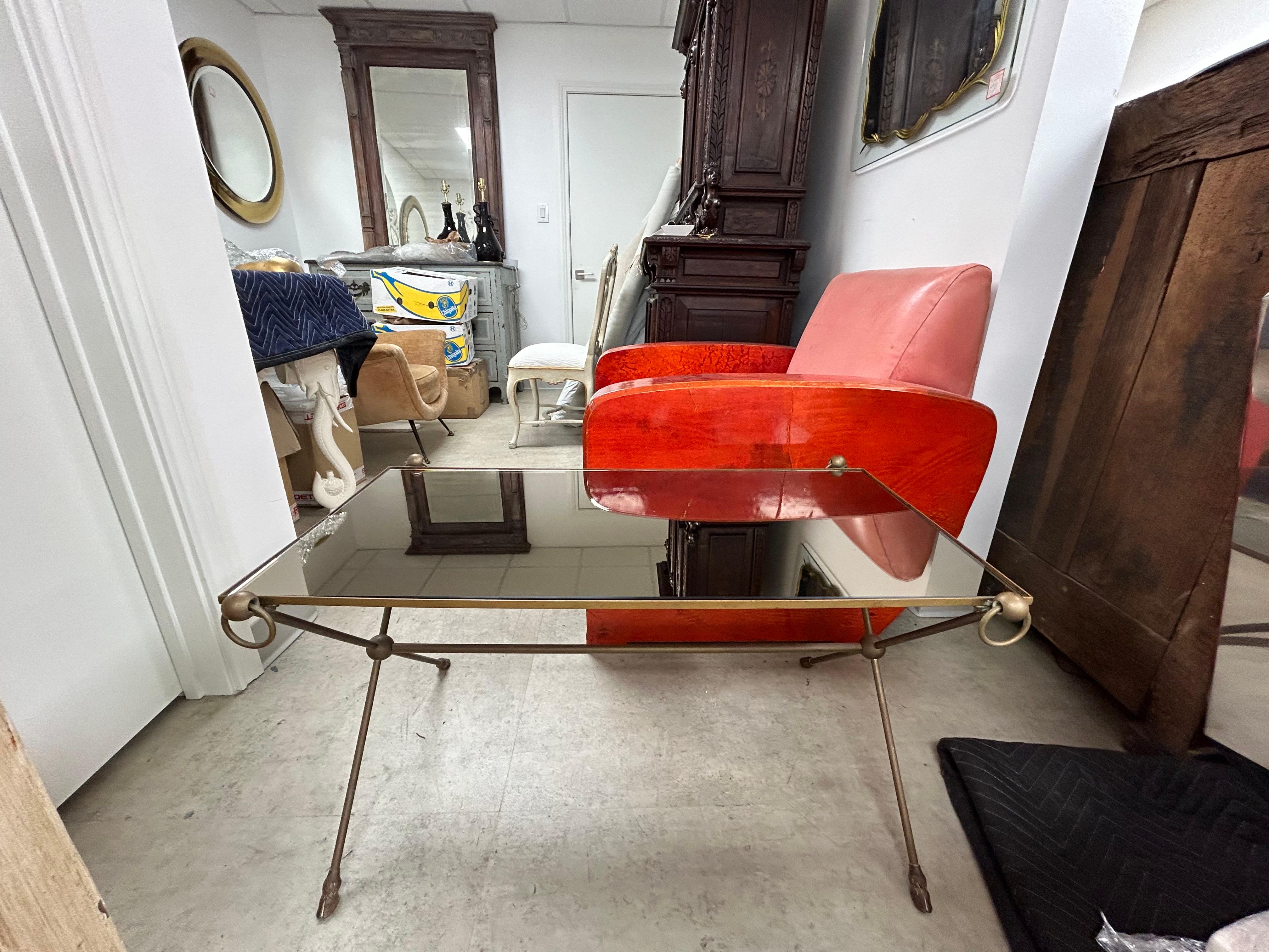French Louis XVI  Style Maison Bagués Inspired Bronze Coffee Table.
This lovely French Louis XVI style bronze coffee table or cocktail table has rings at each corner, hoof feet and a stunning bronze mirrored top. The simplistic sophistication of
