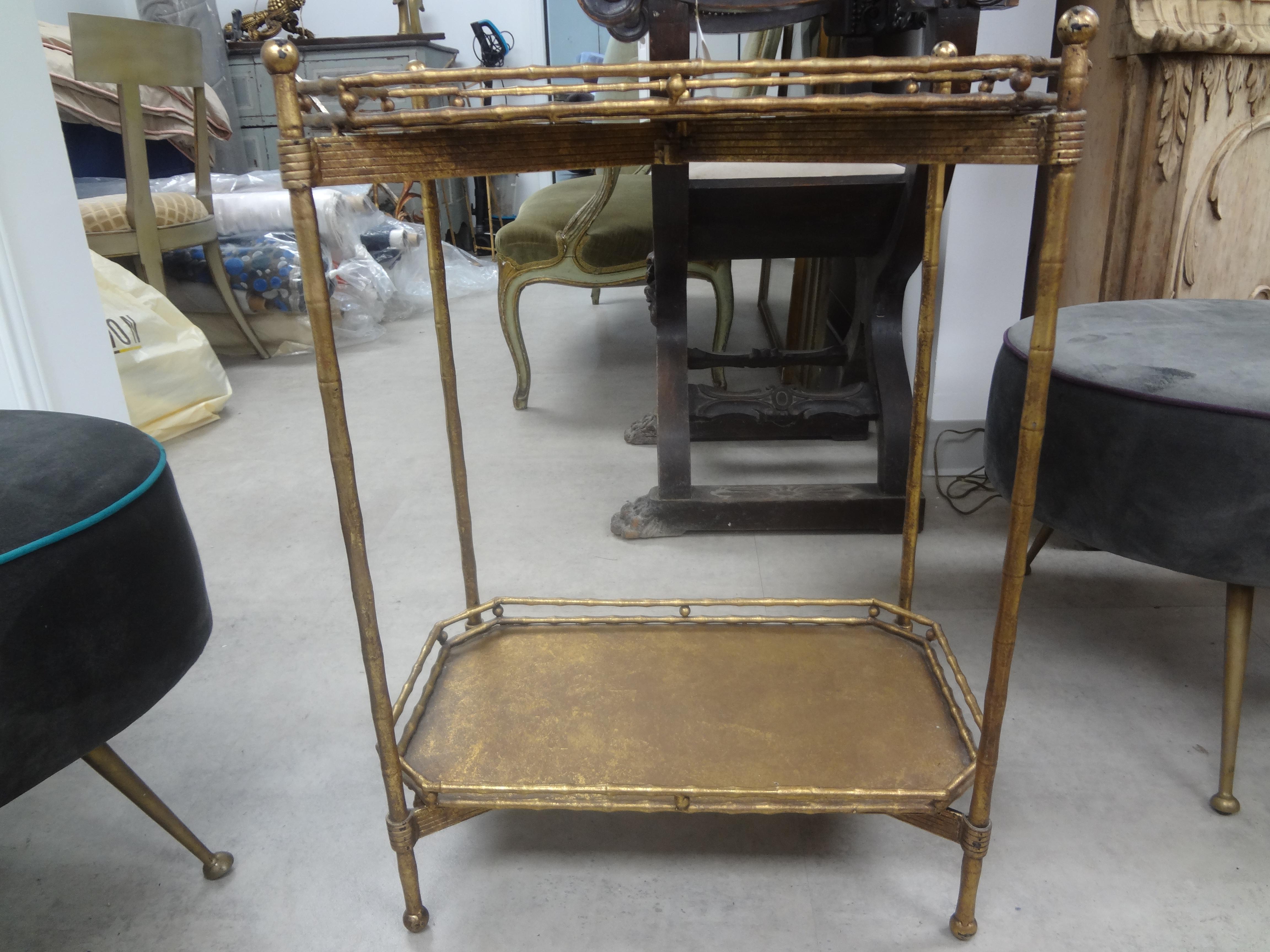 French Louis XVI style Maison Bagues inspired gilt iron table or gueridon. This lovely French Louis XVI or Directoire style two tiered side table or gueridon has a mirrored tray top and a gilt metal tray bottom. Nice patina!