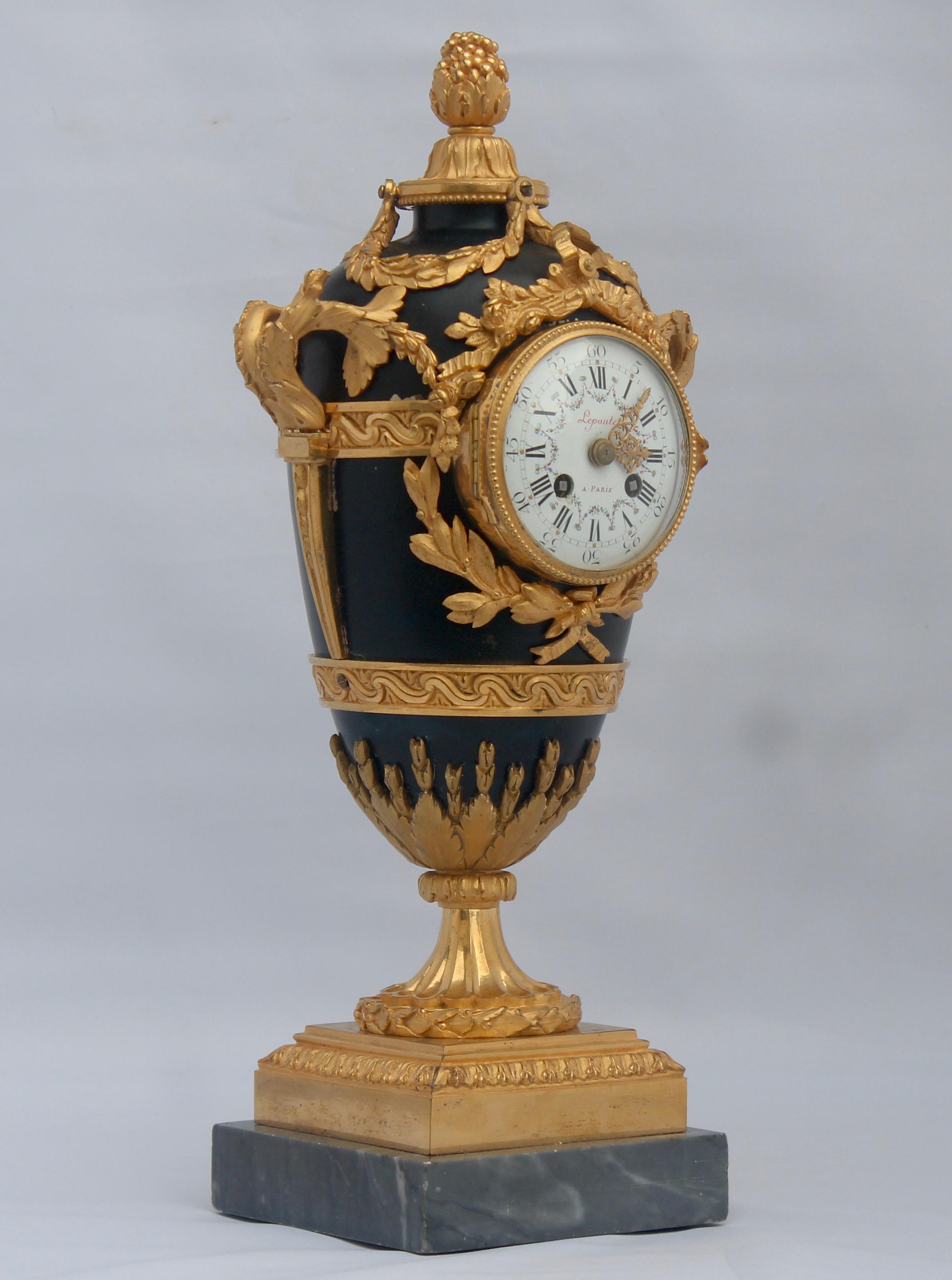 A French Louis XVI style ormolu and lacquered tole covered vase shape mantel clock
Blue lacquered tole covered with ormolu chiseled garlands decorated with flowers and knotted flowers, acanthus and asparagus.
At damping, a seeded bud, it rests on a