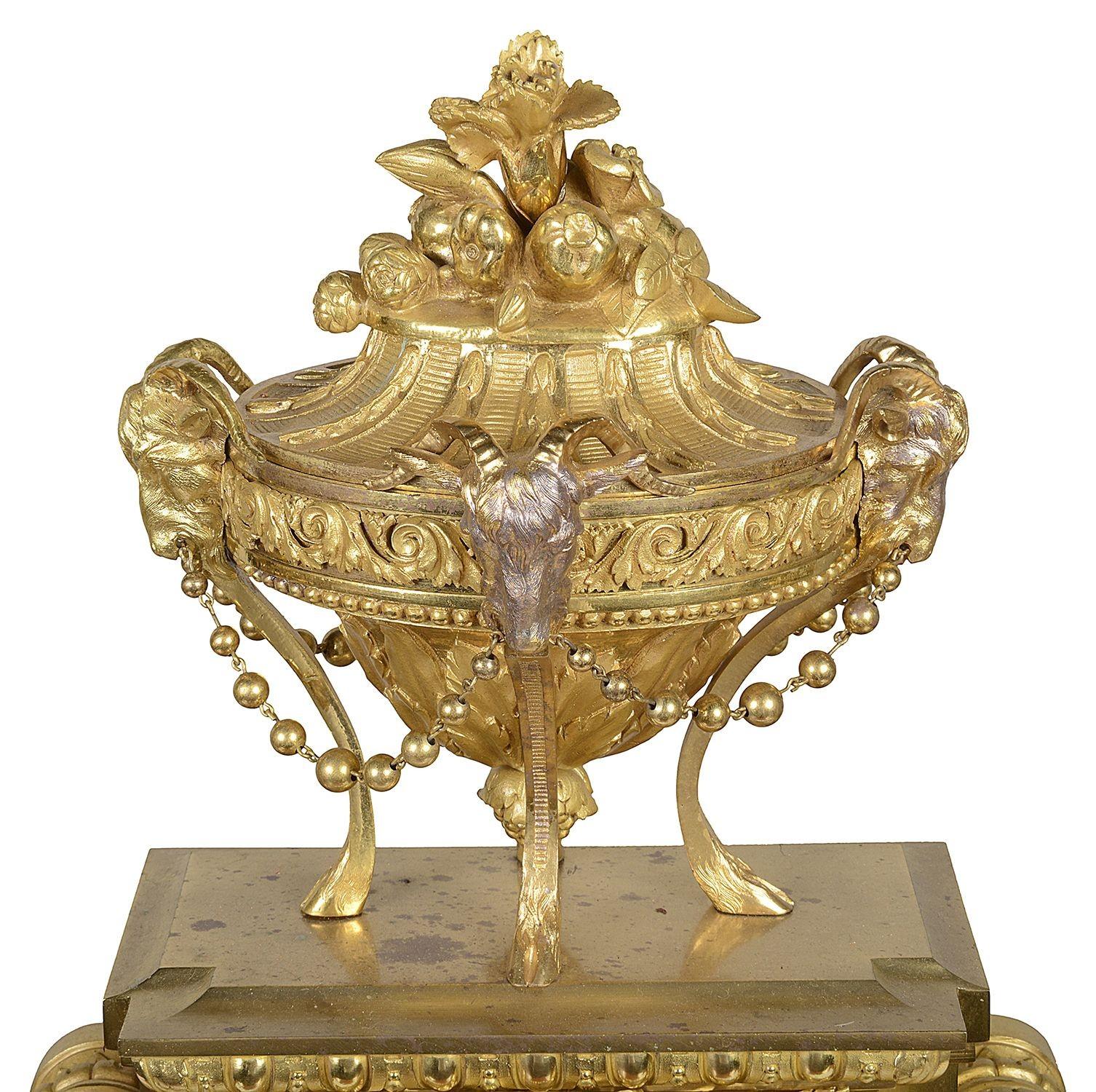 A very good quality mid 19th Century French gilded ormolu Louis XVI style mantel clock with a matched pair of classical five brach candelabra, with putti supporting cornucopia. The clock having a wonderful classical urn with Rams head mounts, the