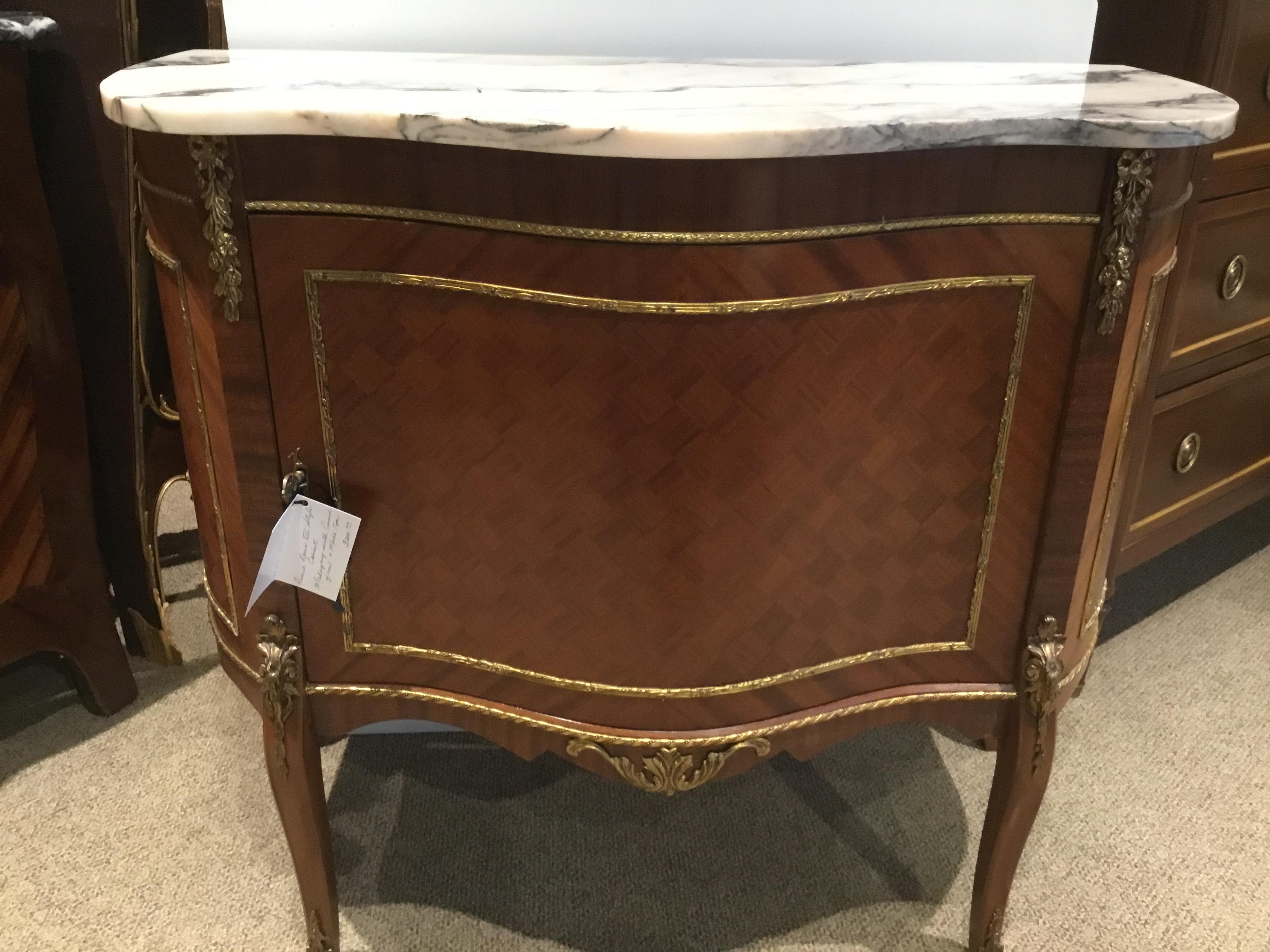 French serpentine shaped cabinet with a marble top with pale gray and
Pale blush color. The marquetry inlay is in superb condition and enhances
This piece on the front and both sides. Bronze doré appliqués decorate
This beautiful cabinet.