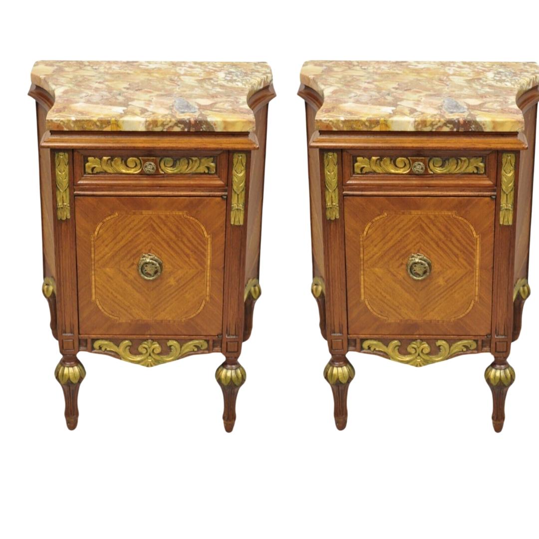 French Louis XVI Style Marble Top Satinwood Inlay Mahogany Nightstands - a Pair. Item features a shaped rouge marble top, tapered legs, curved sides, satinwood mahogany case with sunburst inlay, one swing cabinet door, one drawer, nicely carved gold