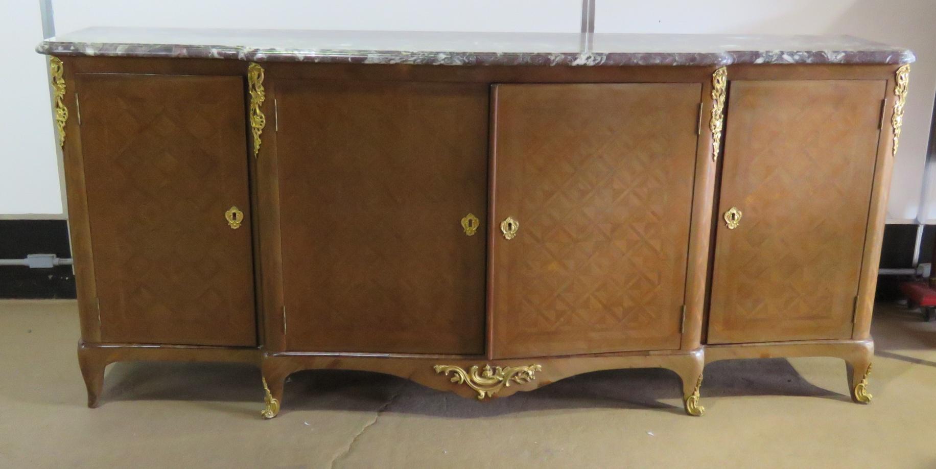 French Louis XVI style inlaid marble-top sideboard with brass accents. The 2 side doors each open to 1 drawer and 1 shelf. The centre doors open to 2 drawers and 2 shelves. Marked 