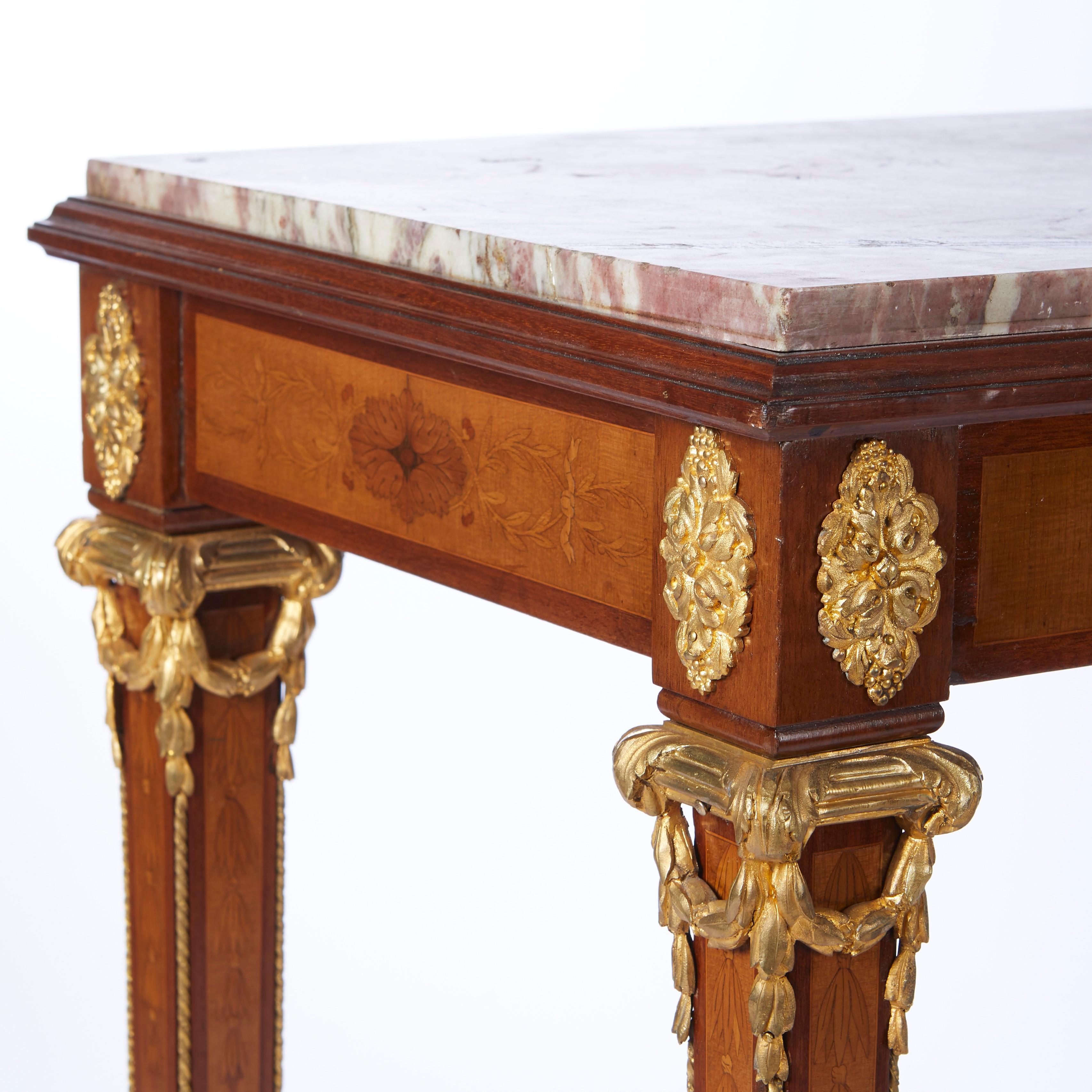 French Louis XVI style marquetry inlaid side table finished on 4 sides apron and legs have contrasting inlay and bronze mounts, top with inset violet colored marble marble. Circa 1920.