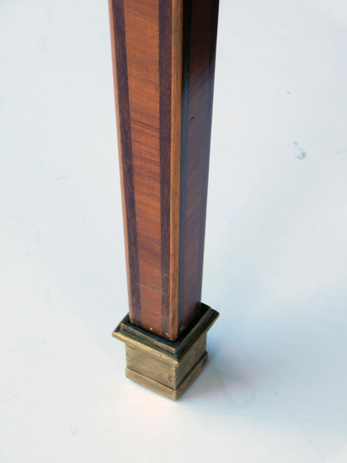 The cross-banded book-matched pie slice veneered oval top with brass mounted perimeter band over a single drawer apron decorated with marquetry inlay; raised on square legs tapering to bronze sabots; oak secondary wood.