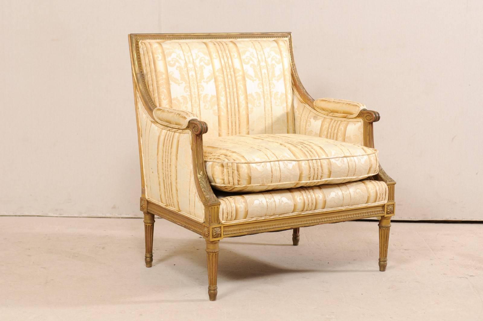 A French Louis XVI style marquise from the turn of the century (late 19th-early 20th century). This antique French painted marquise (a wide bergère chair) has traces of gilding and showcases all the Louis XVI decorative vocabulary with tightly