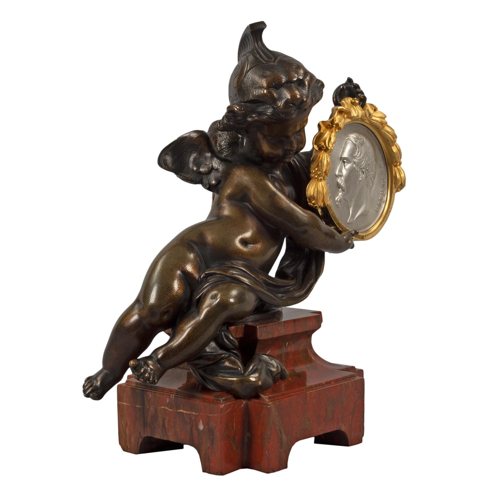 Un'affascinante e insolita statua francese della metà del XIX secolo in bronzo patinato, ormolu, marmo e bronzo argentato. La statua è sollevata da una base rettangolare in marmo Rouge Griotte con angoli tagliati e un design affusolato e screziato.