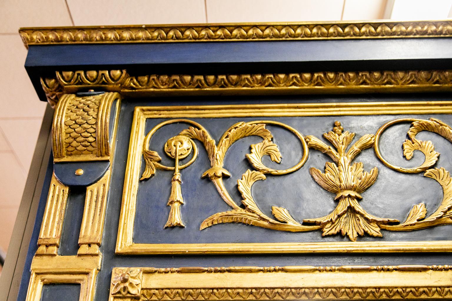 French Louis XVI style mirror has hand carved gilt egg and dart molding on the cornice. The side panels are carved in high relief with leaf and vine panels. The frieze has floral arabesques with pendant tassels. The mirror is beveled and slightly
