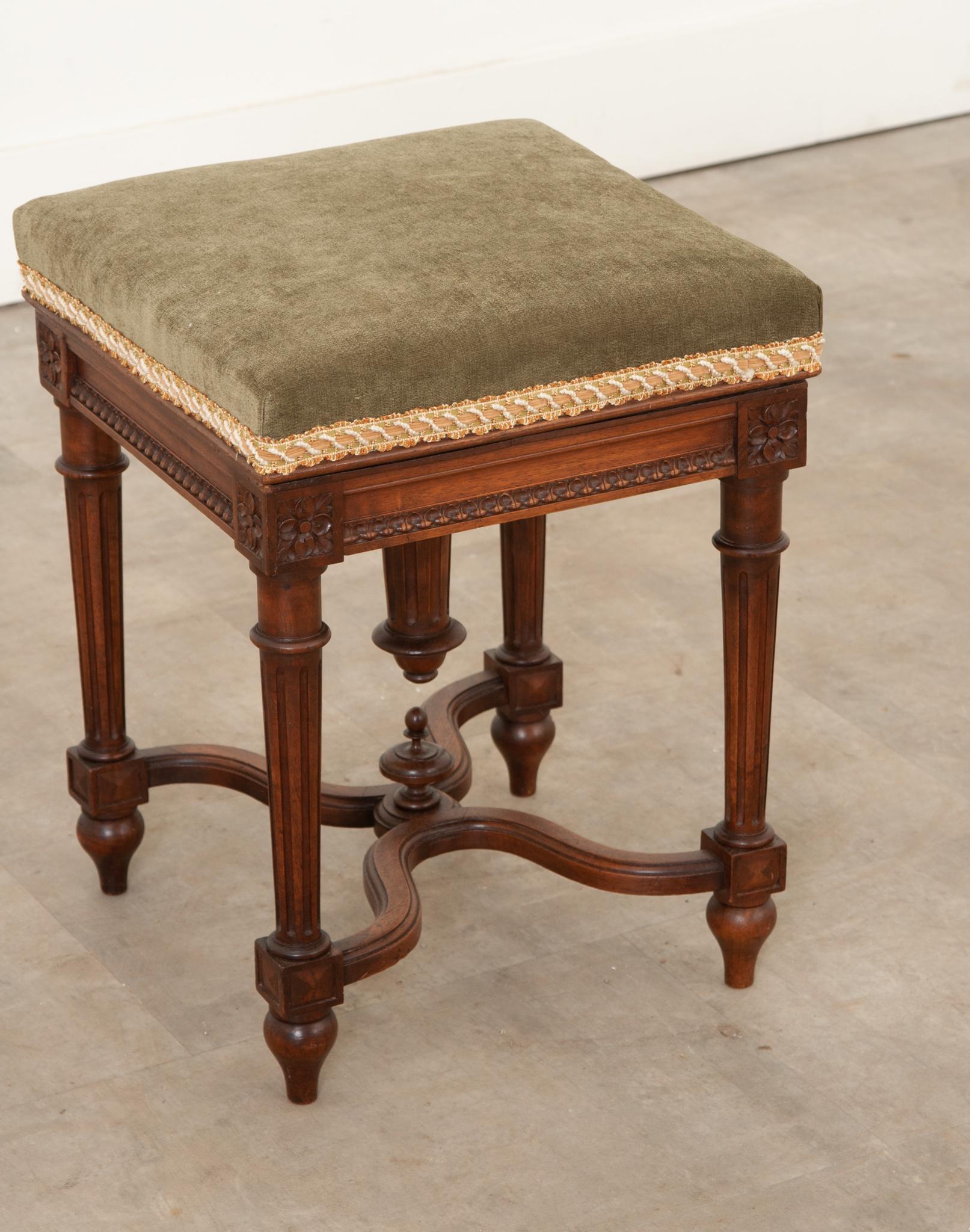 This French 19th century oak piano stool is an elegant and classic example of Louis XVI style. Made in France, the piano stool was hand-crafted out of solid oak for a sturdy build, and is accented with intricately carved details on the corners that