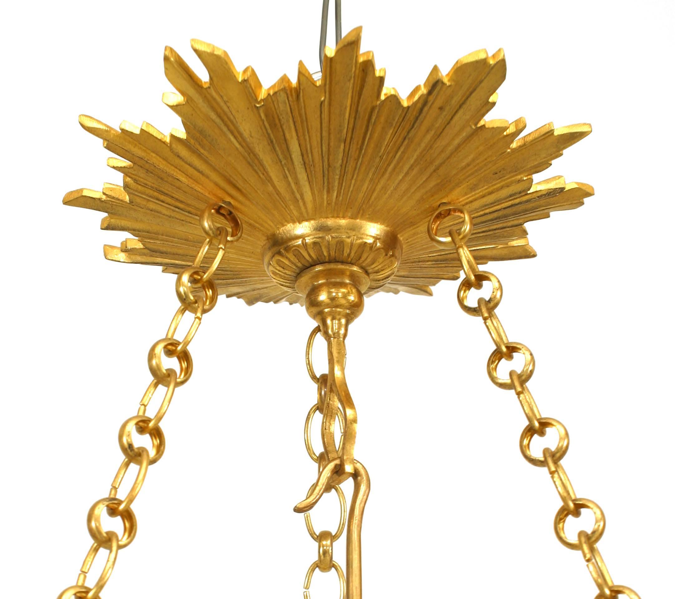French Louis XVI style ormolu lantern with chain suspended glass canopy with ram headed Vitruvian scrolled rim and three arms from a central rod (20th century).
 