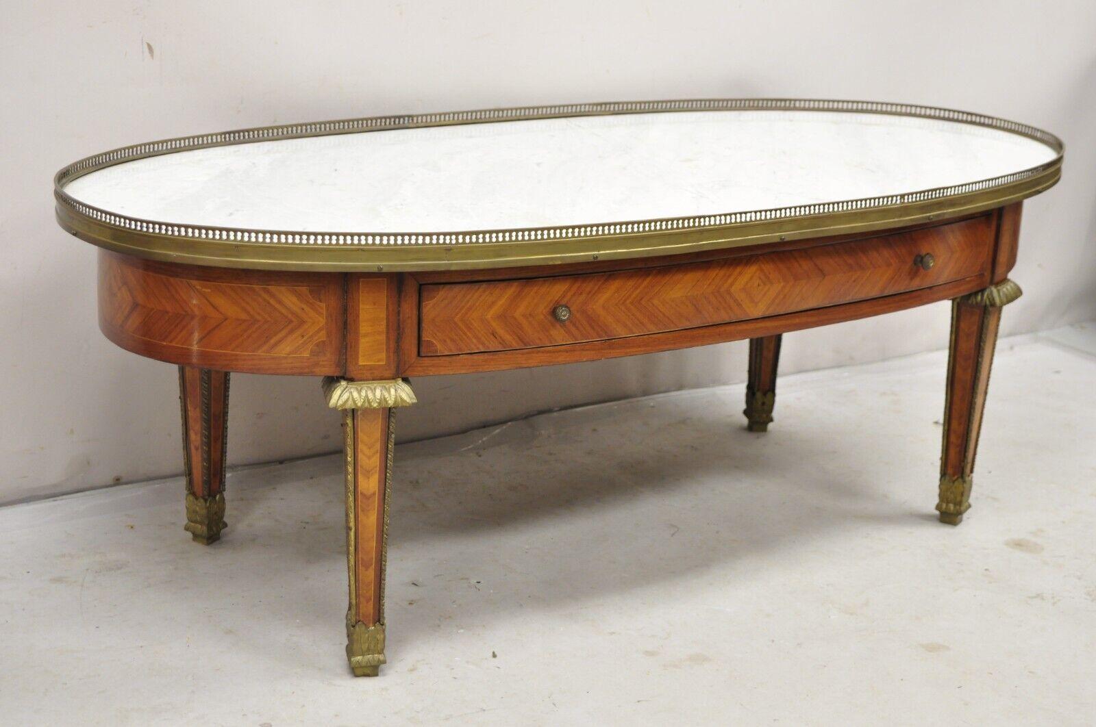 Vintage French Louis XVI Style Oval Marble Top Bronze & Satinwood Coffee Table w/ Drawer. Item features an ornate bronze ormolu mounts and gallery, single drawer, inlaid and finished on all sides, very impressive French coffee table. Circa 1930s.