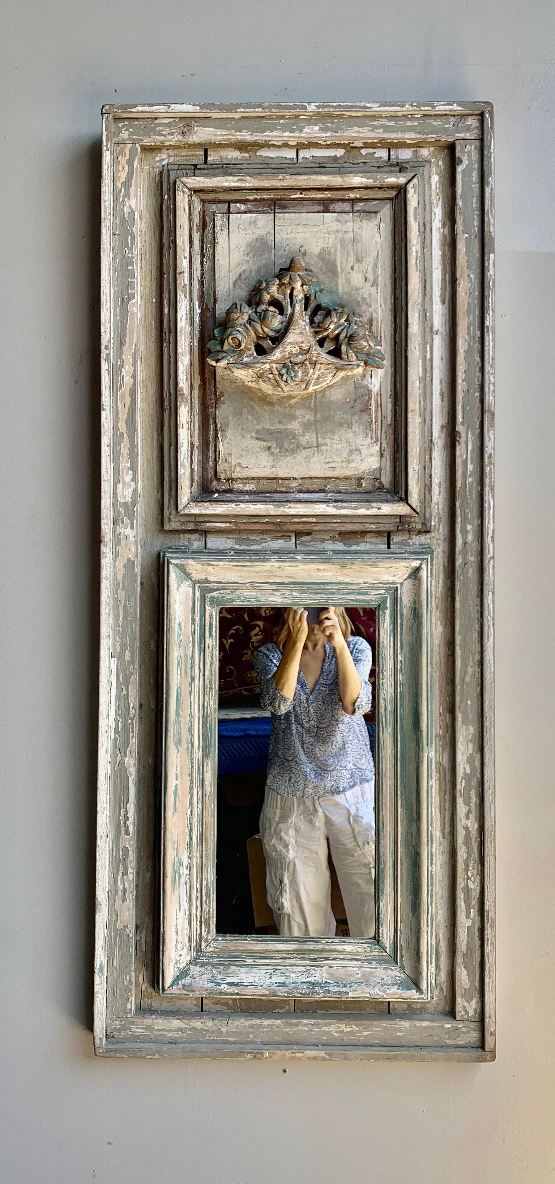 Early 20th century carved wood painted trumeau with a center carved basquet of flowers at the top of the mirror. Beautiful worn paint throughout. Great scale for smaller entry or powder room.