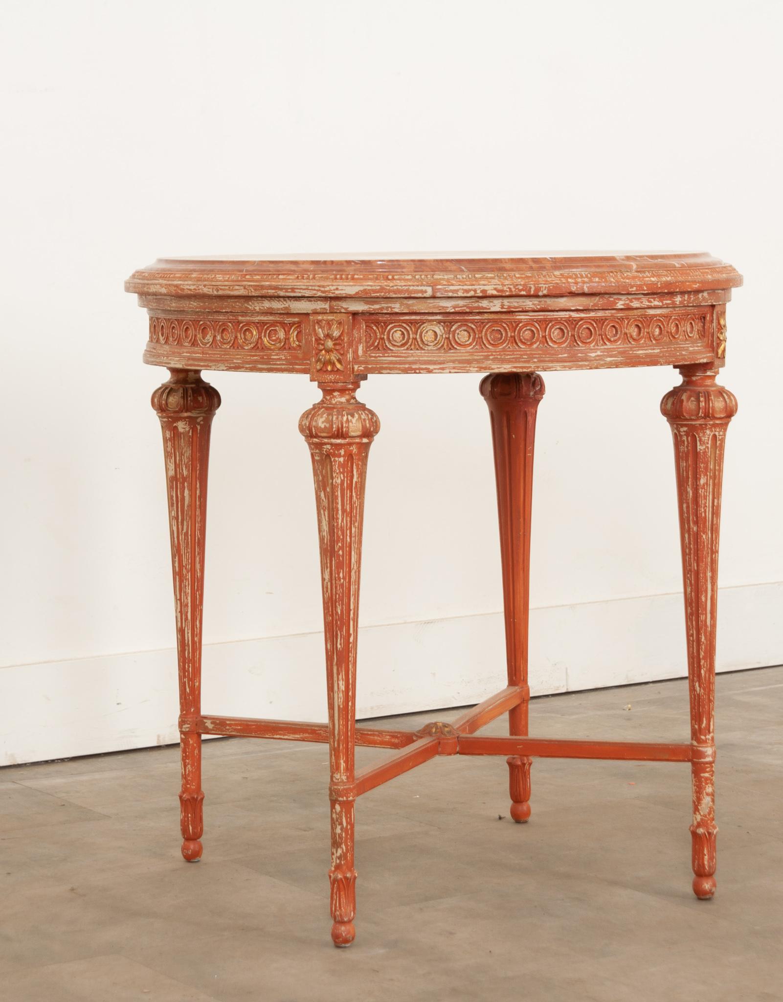 Hand-carved in France during the 19th Century this Louis XVI style round table features a thick gorgeous inset marble top with a chamfered edge. The rosewood colored stone top with white and charcoal veining and wonderful patterns throughout  rests