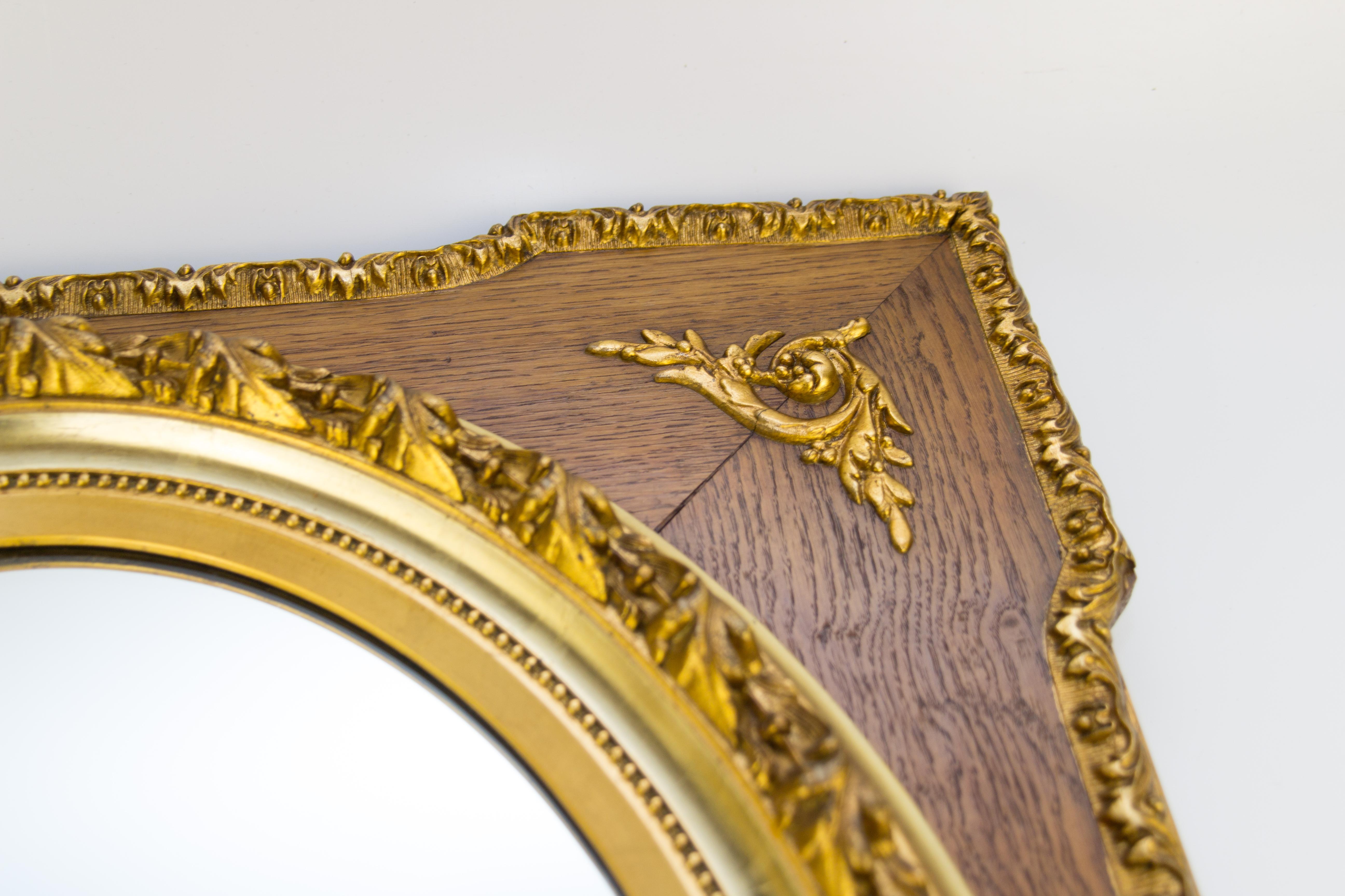 A French Louis XVI style rectangular massive oak frame with central oval mirror plate, surrounded with a parcel-gilt garland molding, decorated with gold-colored acanthus leaves ornaments, made of composition material. From the 1920s.
Dimensions: