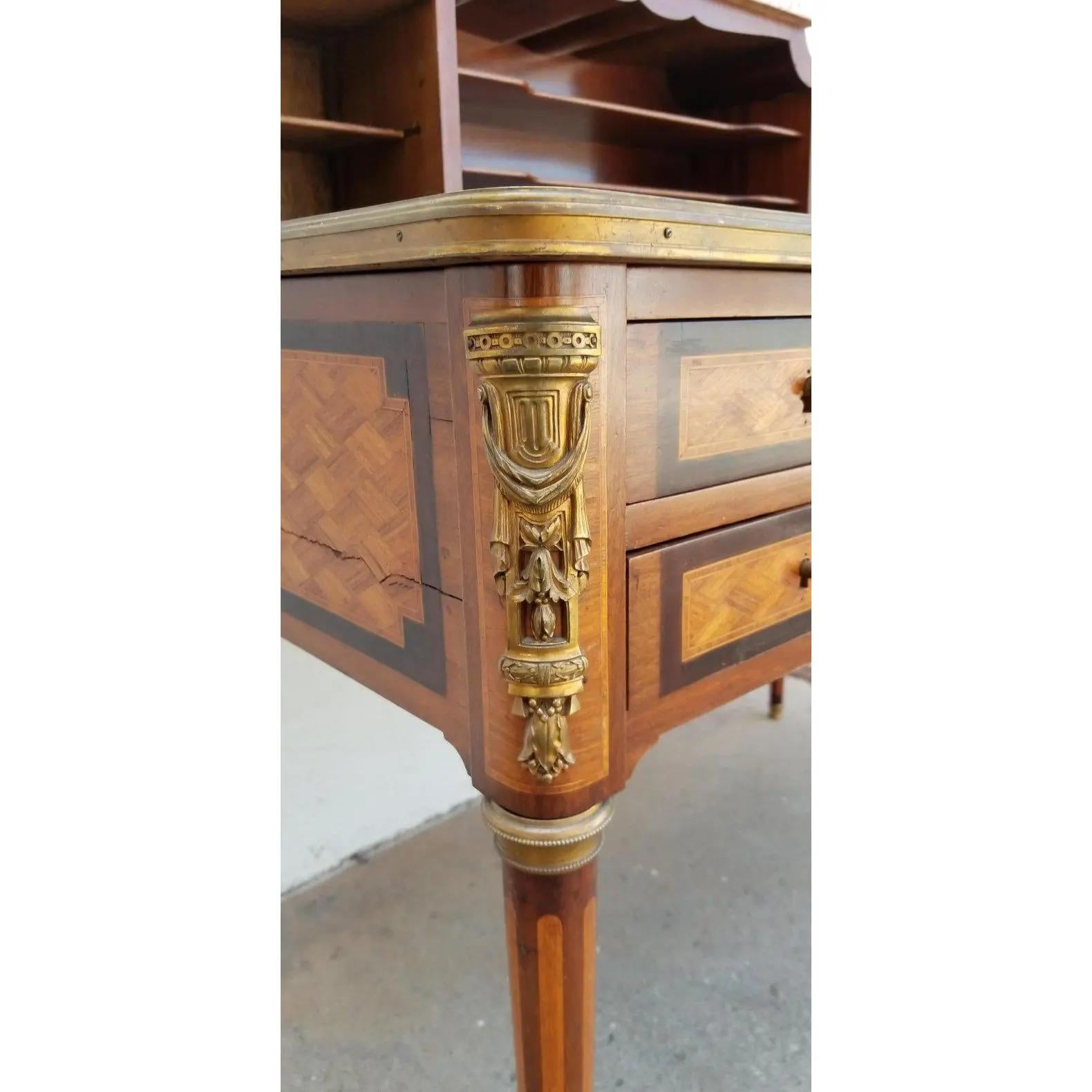 Early 20th century parquetry desk or writing table with bronze ormolu detail and tooled leather writing surface. Fine detail to gilded bronze mounts, beveled marble top. Five drawers, two shelves and tambour storage cabinets. Beautiful original