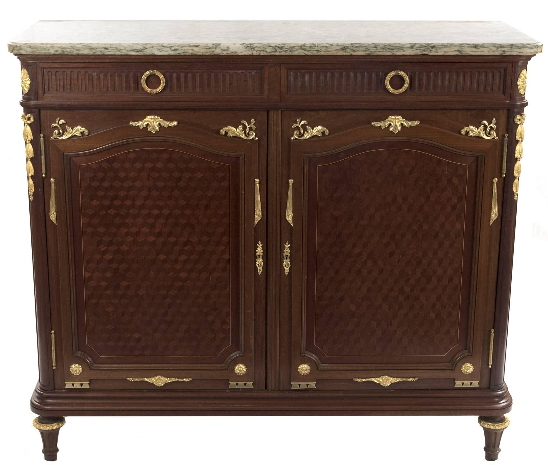 A late 19th century French Louis XVI style server with a green marble top above two long drawers, constructed with mortise and tenon drawer joints, with fluted fronts and round gilt-bronze pulls, flanked by ormolu rosettes on rounded corners. Two