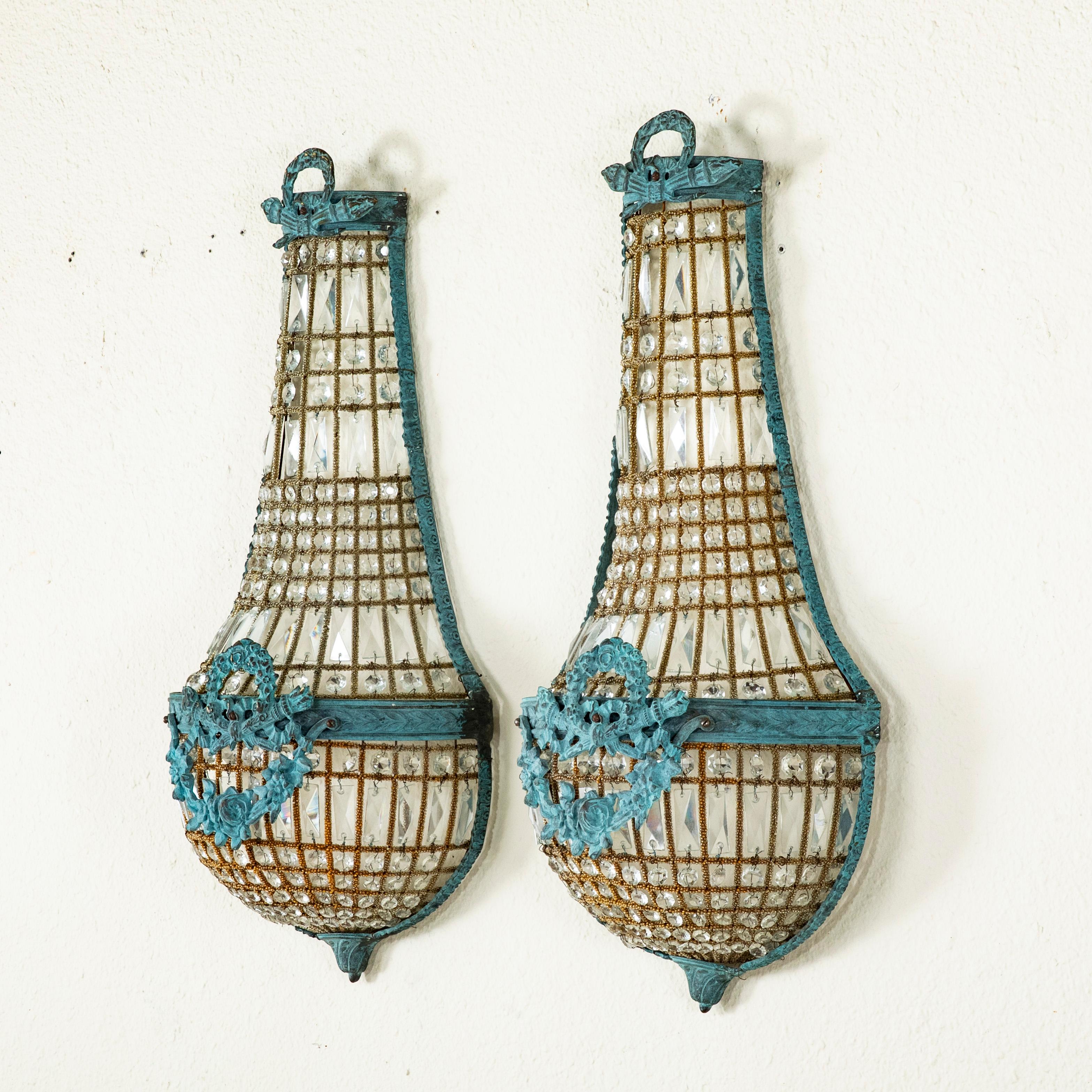 This pair of mid-century French Louis XVI style patinated metal sconces take the form of upside down hot air balloons and are detailed with beading and multi-faceted strings of glass beads. The sconces are finished with Classic Louis XVI crossed