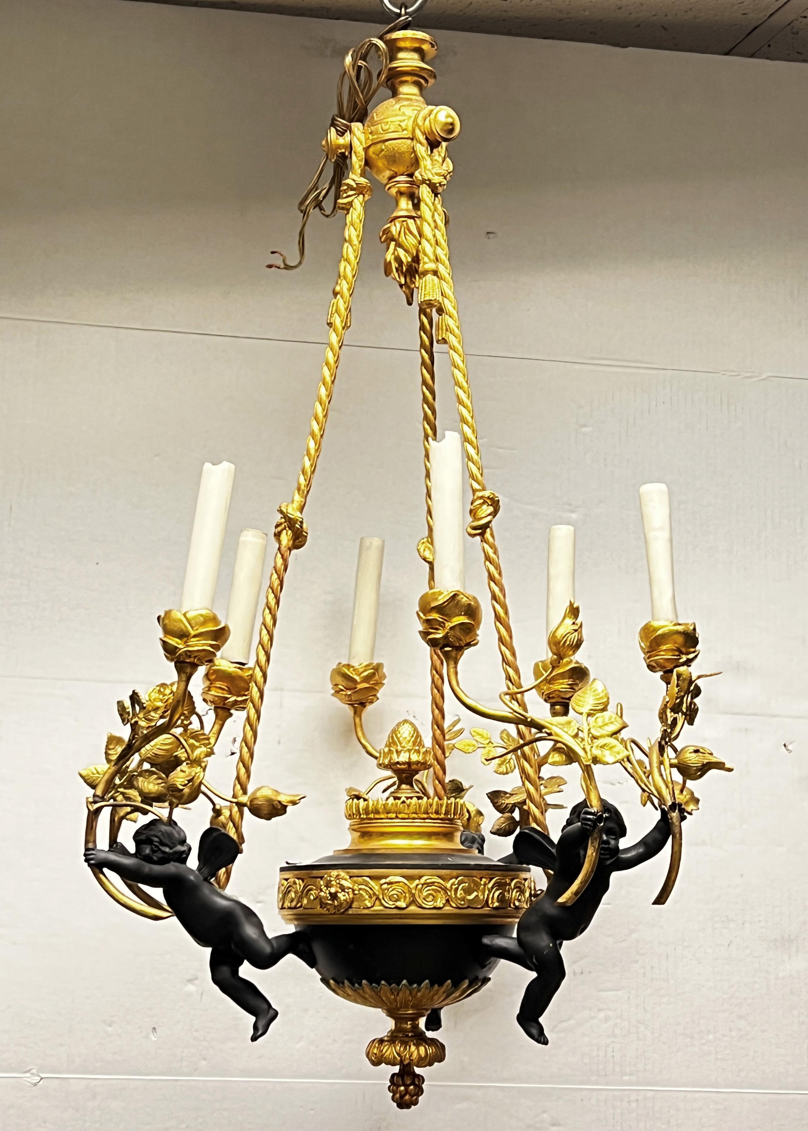 Début du 20ème siècle Lustre à six lumières de style Louis XVI en bronze patiné à motif de putti en vente