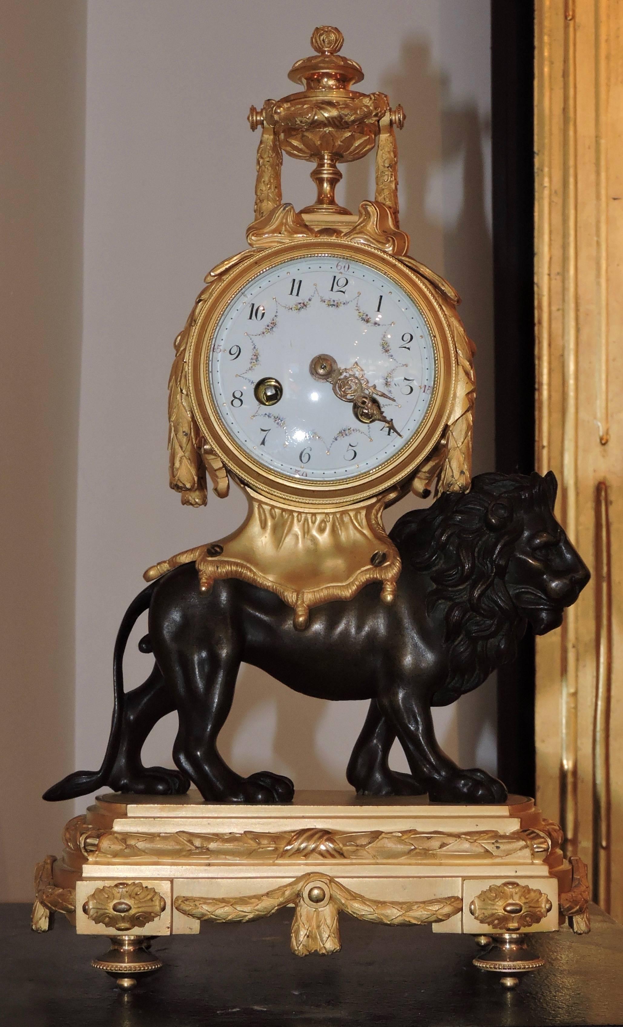 A French Louis XVI style ormolu and patinated bronze pendule au lion
The clock surmounted by a covered urn, mounted on the back of a patinated bronze lion with mane and serpentine tail on a rectangular base on which are suspended garlands of laurel