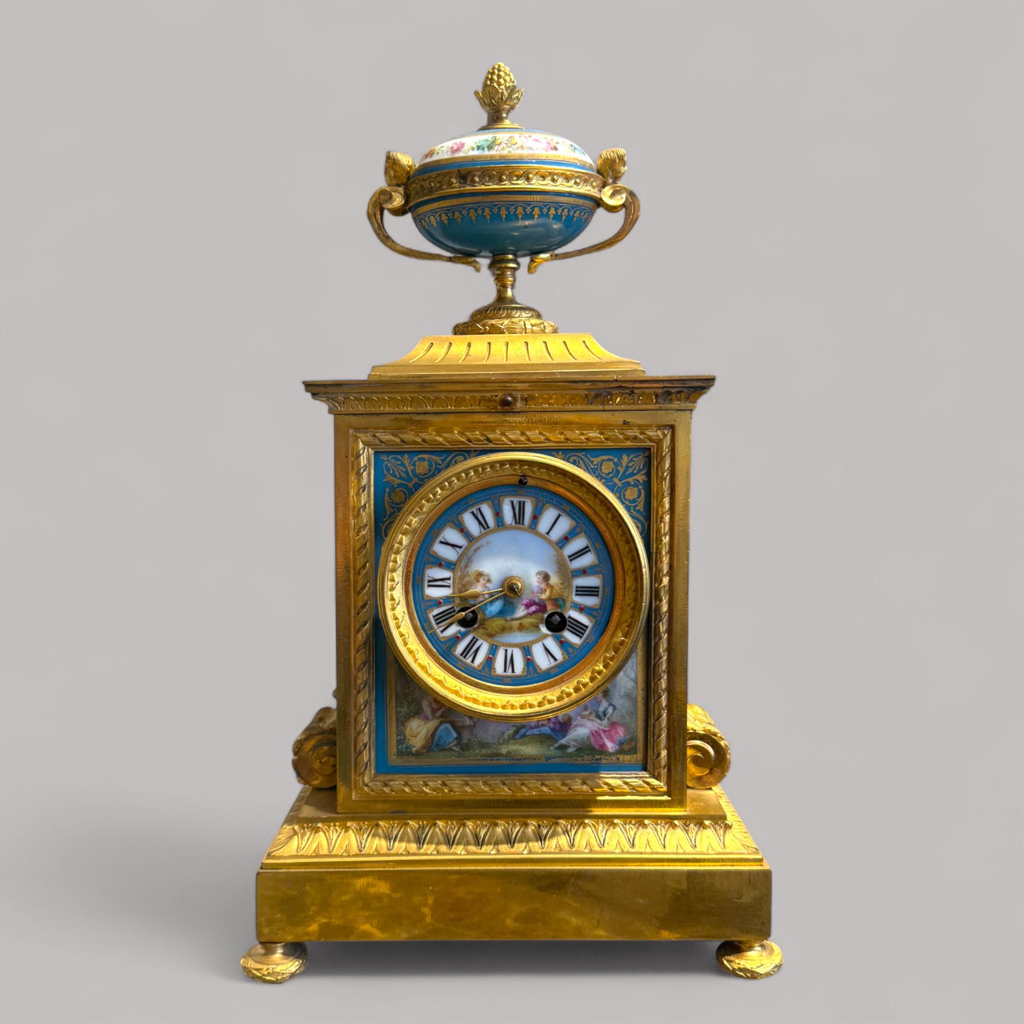 Elegante orologio da camino in bronzo dorato e porcellana dipinta a mano, realizzato in stile Luigi XVI e risalente al XIX secolo.

La cassa rettangolare in bronzo dorato è ornata da motivi di acanto, fregi contorti e poggia su piedi torniti.