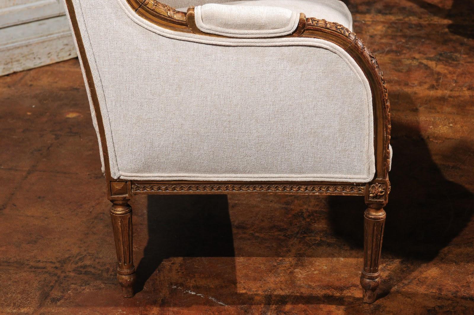A French Louis XVI style wingback chair from the 19th century, with richly carved décor, intertwining beads, foliage and new upholstery. This French Louis XVI style bergère à oreilles features an exceptional hand carved décor on the frame and has