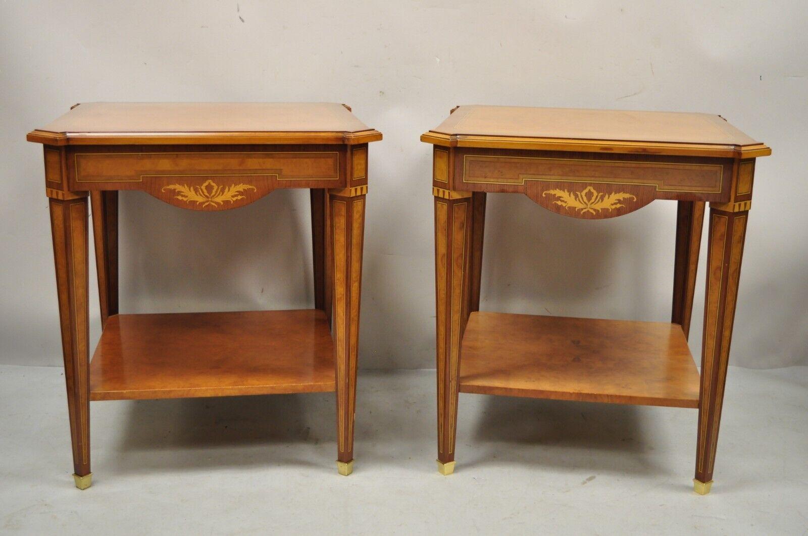 French Louis XVI Style Satinwood Inlay Side End Tables by Mudeva - a Pair. Item features brass capped feet, 2 tiers, satinwood inlay, solid wood construction, beautiful wood grain, original label, tapered legs, quality craftsmanship, great style and