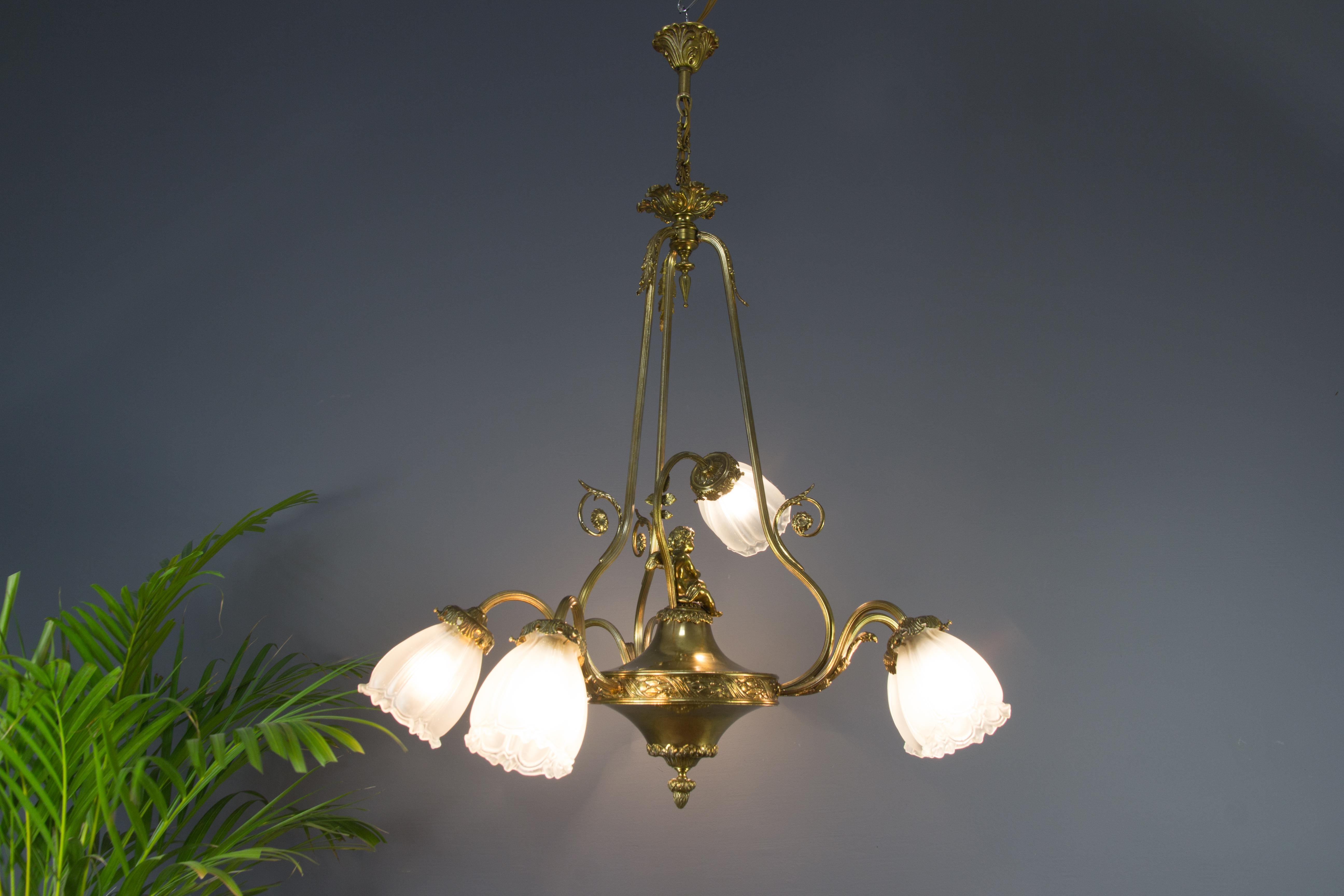 French Louis XVI style seven-light chandelier made of brass and bronze in the 1920s. Bronze details of acanthus leaves and a sitting cherub figurine. Seven beautifully shaped frosted glass shades with sockets for E 27 size light bulbs.
Dimensions: