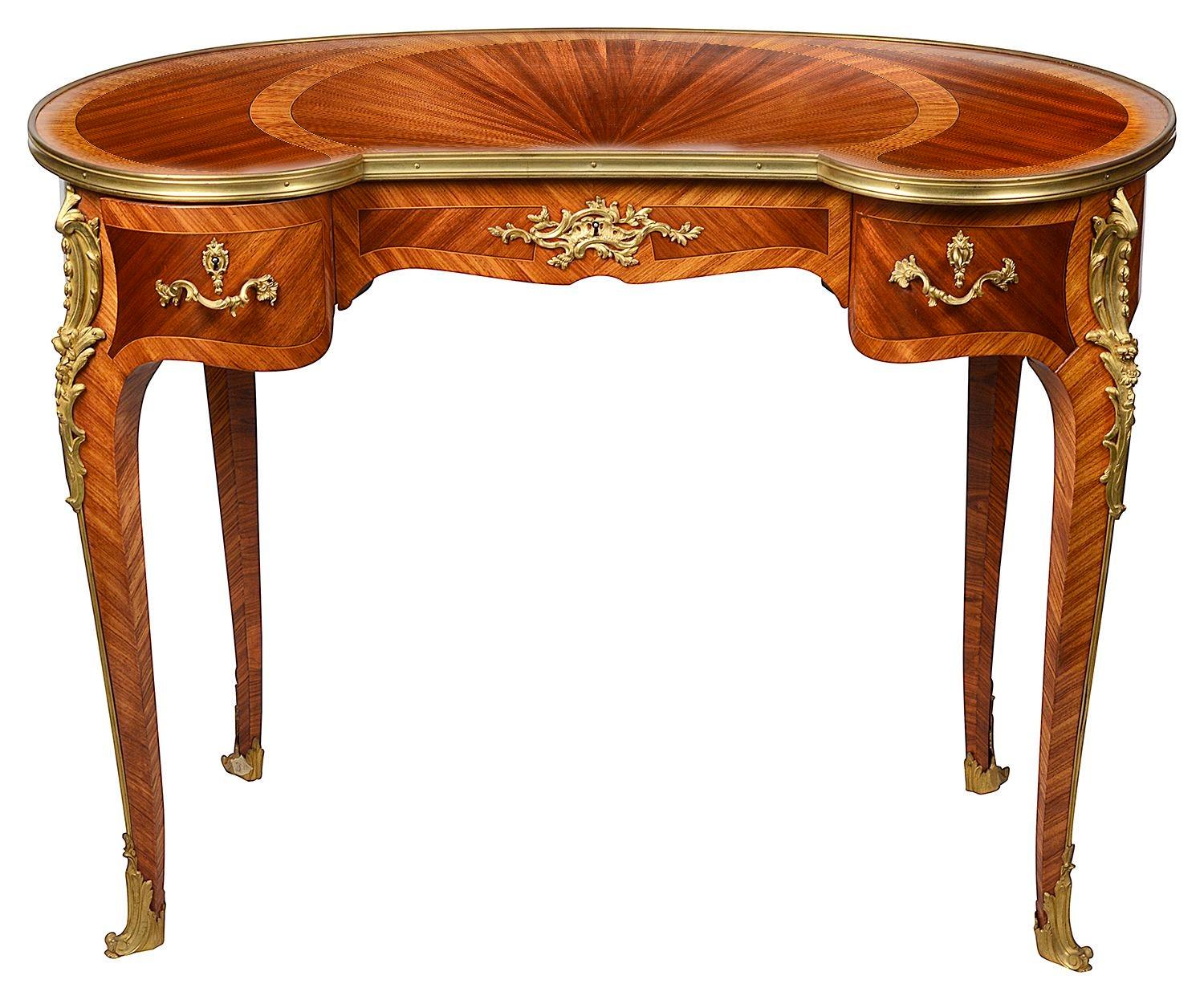 Table d'appoint de la fin du 19e siècle en parquet français incrusté, en forme de rein, avec un seul tiroir en frise. Le plateau présente de magnifiques placages à bandes croisées et rayonnantes. Montures en bronze doré et reposant sur d'élégants