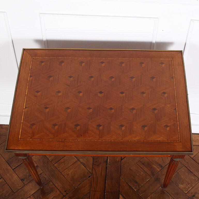 French mahogany Louis XVI style side table, the top with diamond parquet within a banded inlaid border and with a brass edge, the sides with further inlaid satinwood banding, the whole raised on turned tapering fluted legs with brass cuffs and feet.