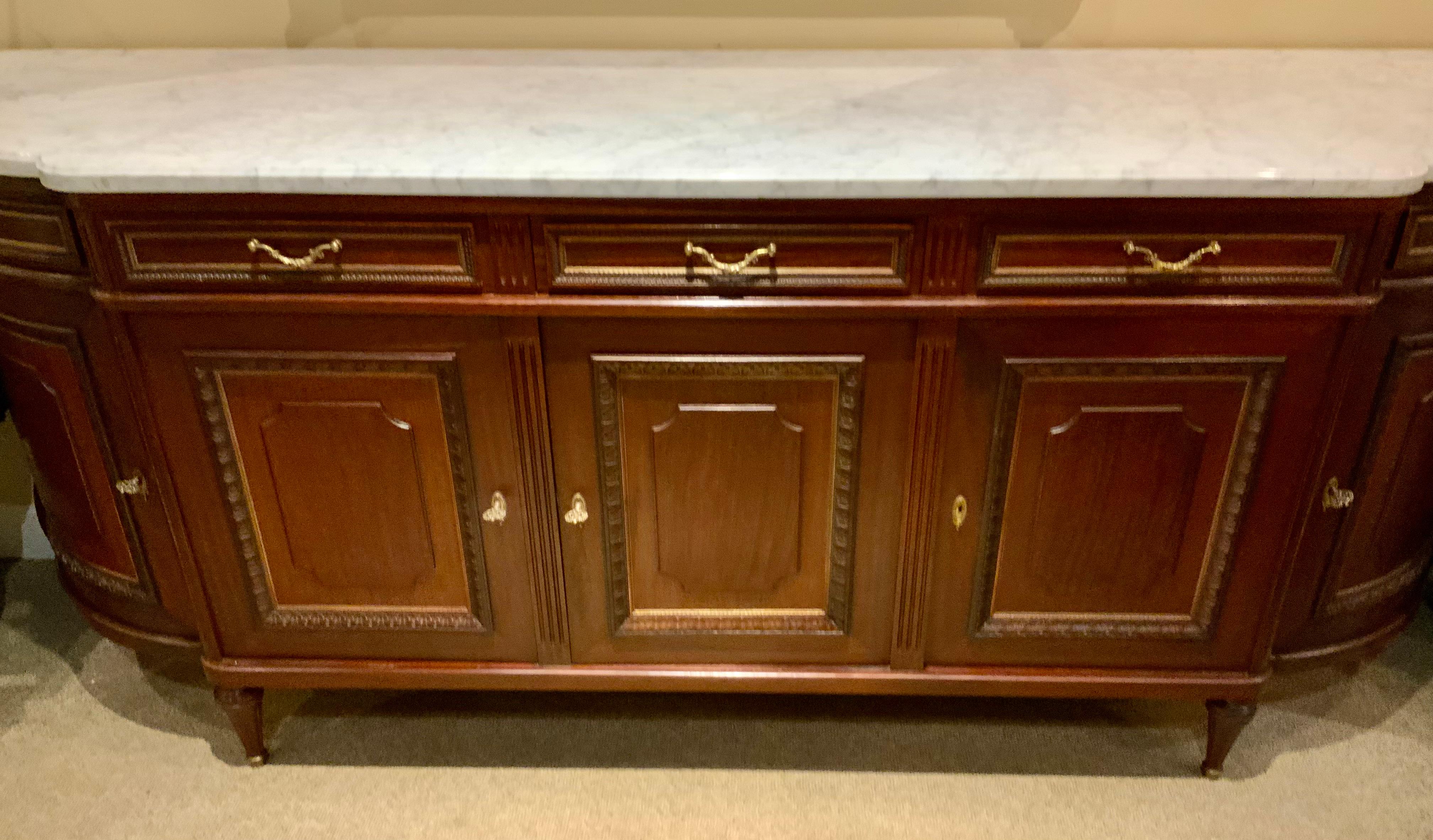 This outstanding buffet in the Louis XVI-Style has exceptional 
Design with graceful curved sides. The storage is abundant 
With shelves and drawers with locks and keys. The cabinetry
Is of exquisite in quality. The marble has had no restorations