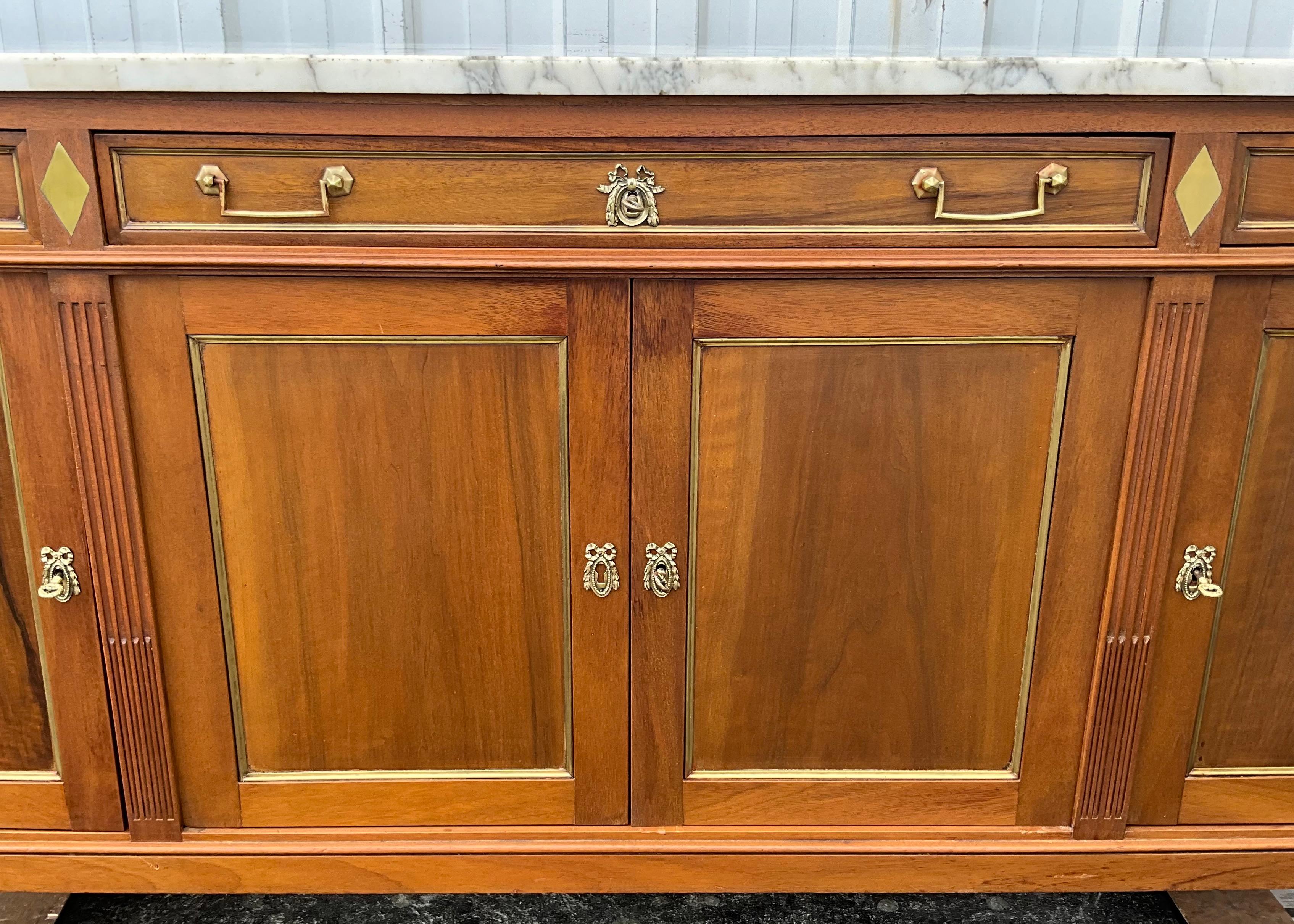 French walnut sideboard period early 20th style Louis XVI.

This row opens to four doors and three drawers (two medium and a large central part).

This piece of furniture is the result of a work of a Parisian cabinetmaker, passionate about its