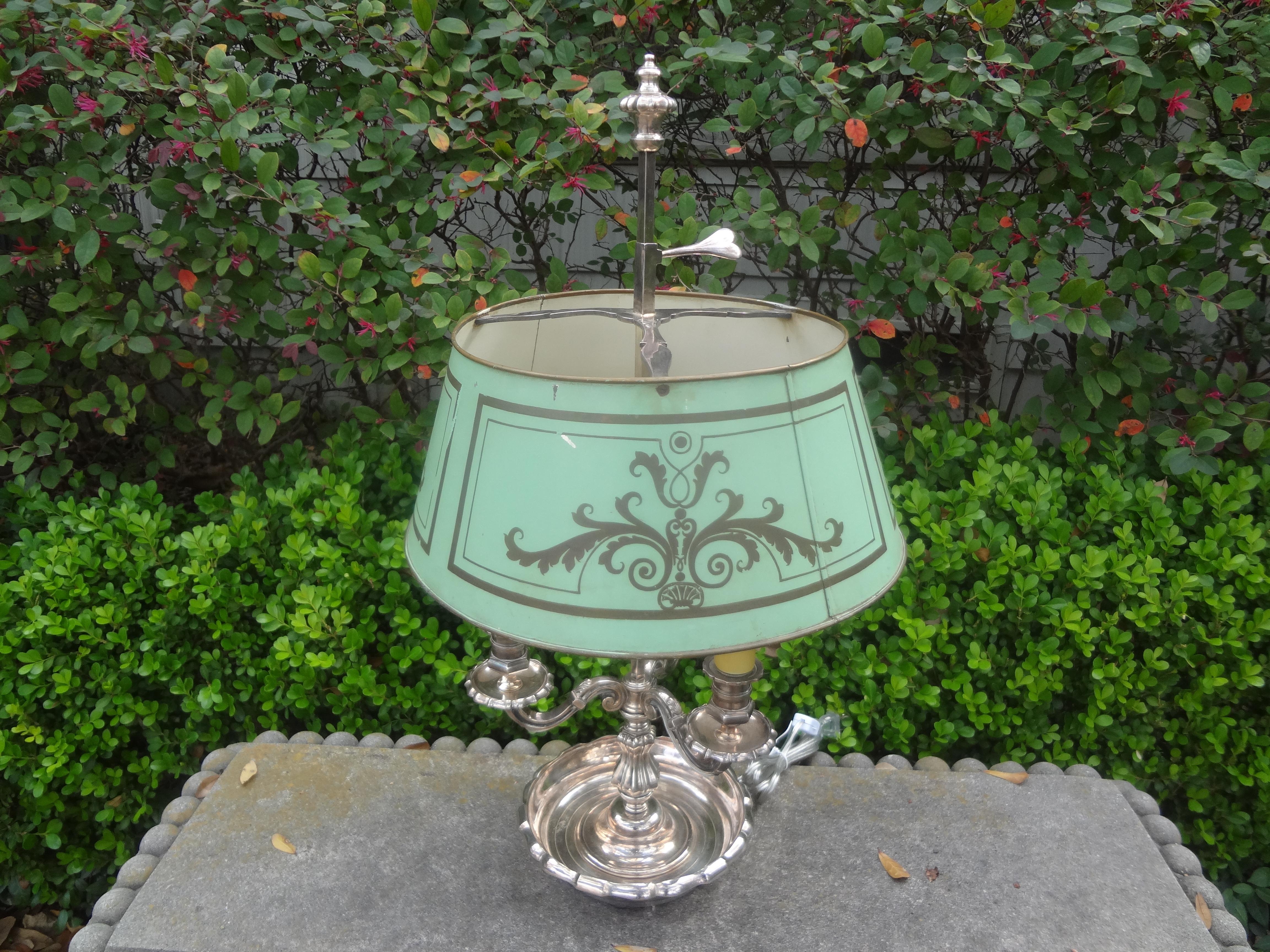 French Louis XVI Style silver plated bronze bouillotte lamp.
This stunning antique French Louis XVI style silver plated bronze bouillotte lamp or desk lamp with tole shade and three lights has been newly wired with new sockets for the U.S. market