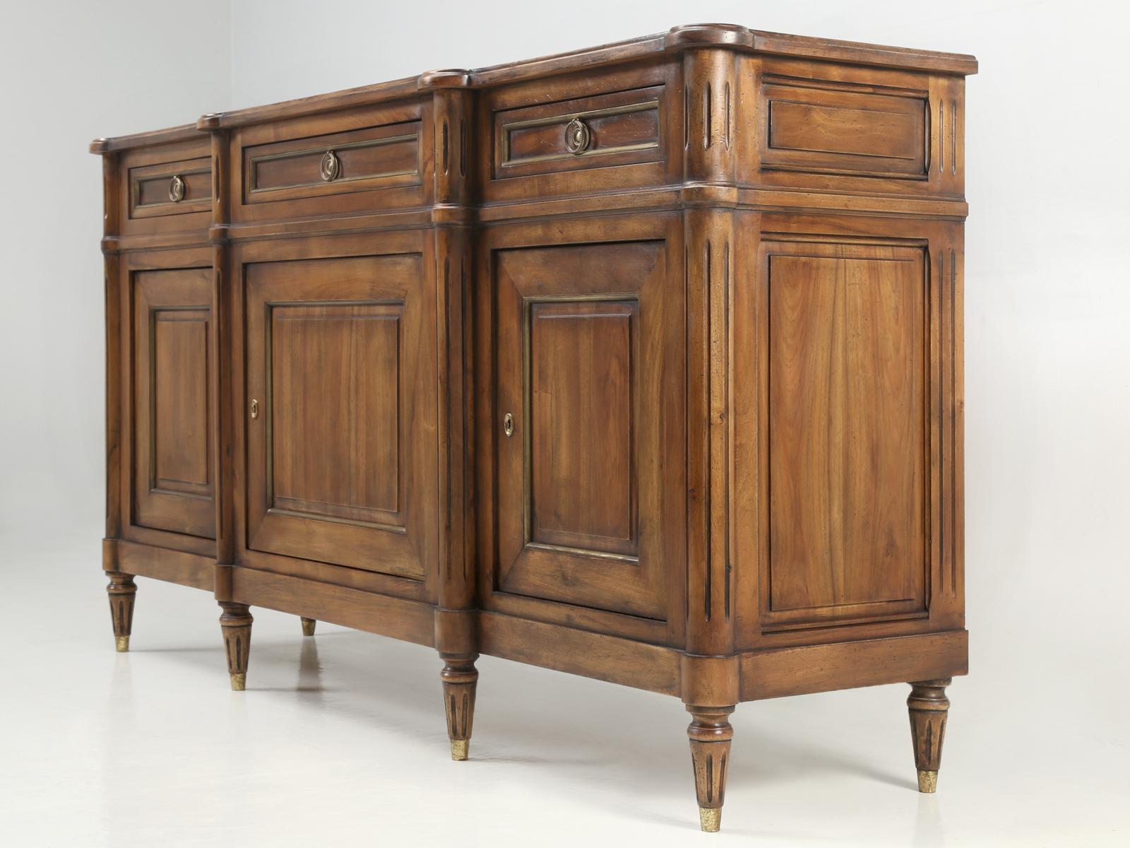 Vintage French Louis XVI style buffet constructed from solid walnut and accented with real brass trim. Our old plank restoration department removed the previous and discolored finish, without the use of any harsh chemicals and then applied an old