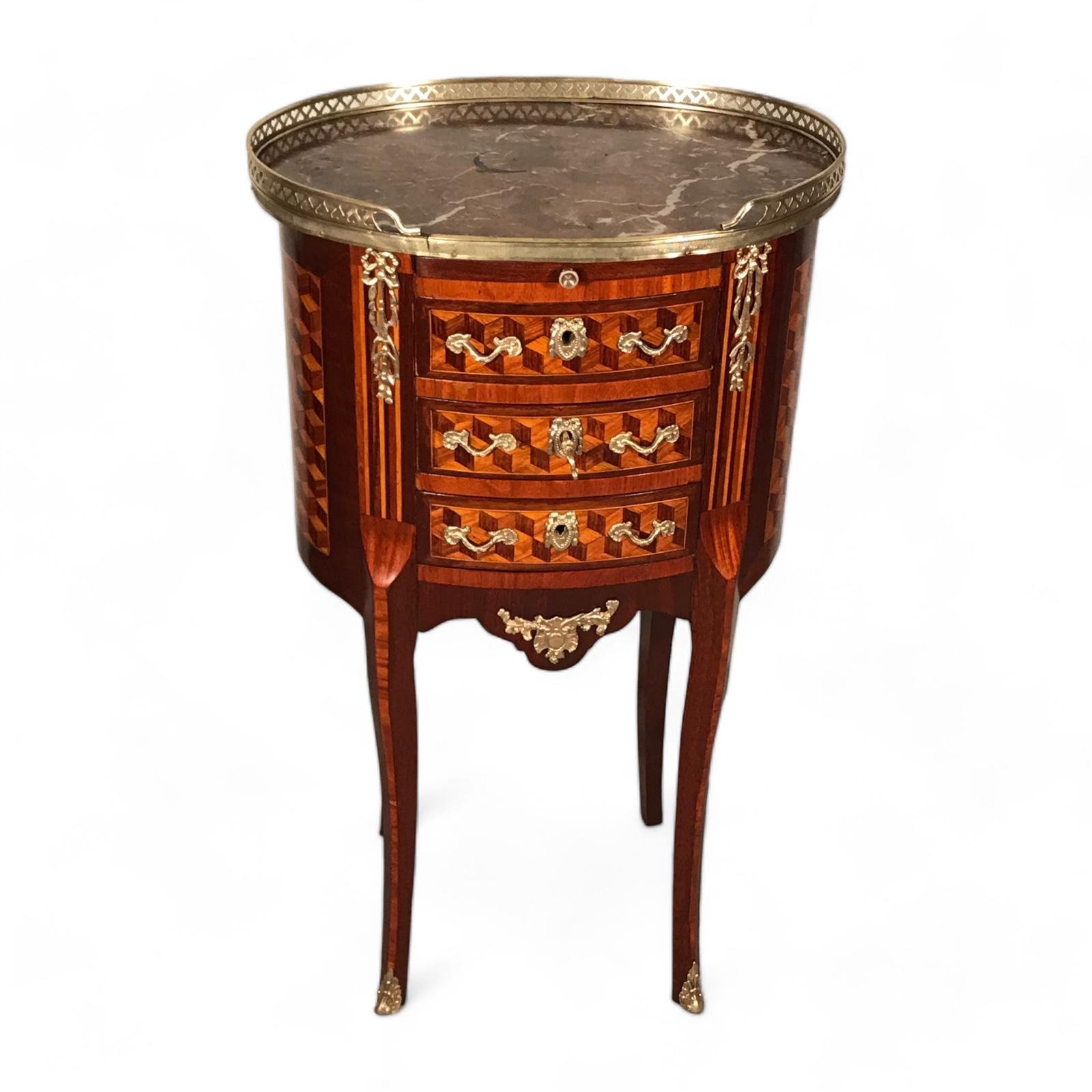 Der Beistelltisch Tambour im Louis XVI-Stil, der für seine exquisiten Blockintarsien bekannt ist, ist ein herausragendes Möbelstück. Dieser zeitlose Beistelltisch mit drei Schubladen und einer ausziehbaren Platte bietet Funktionalität und Eleganz