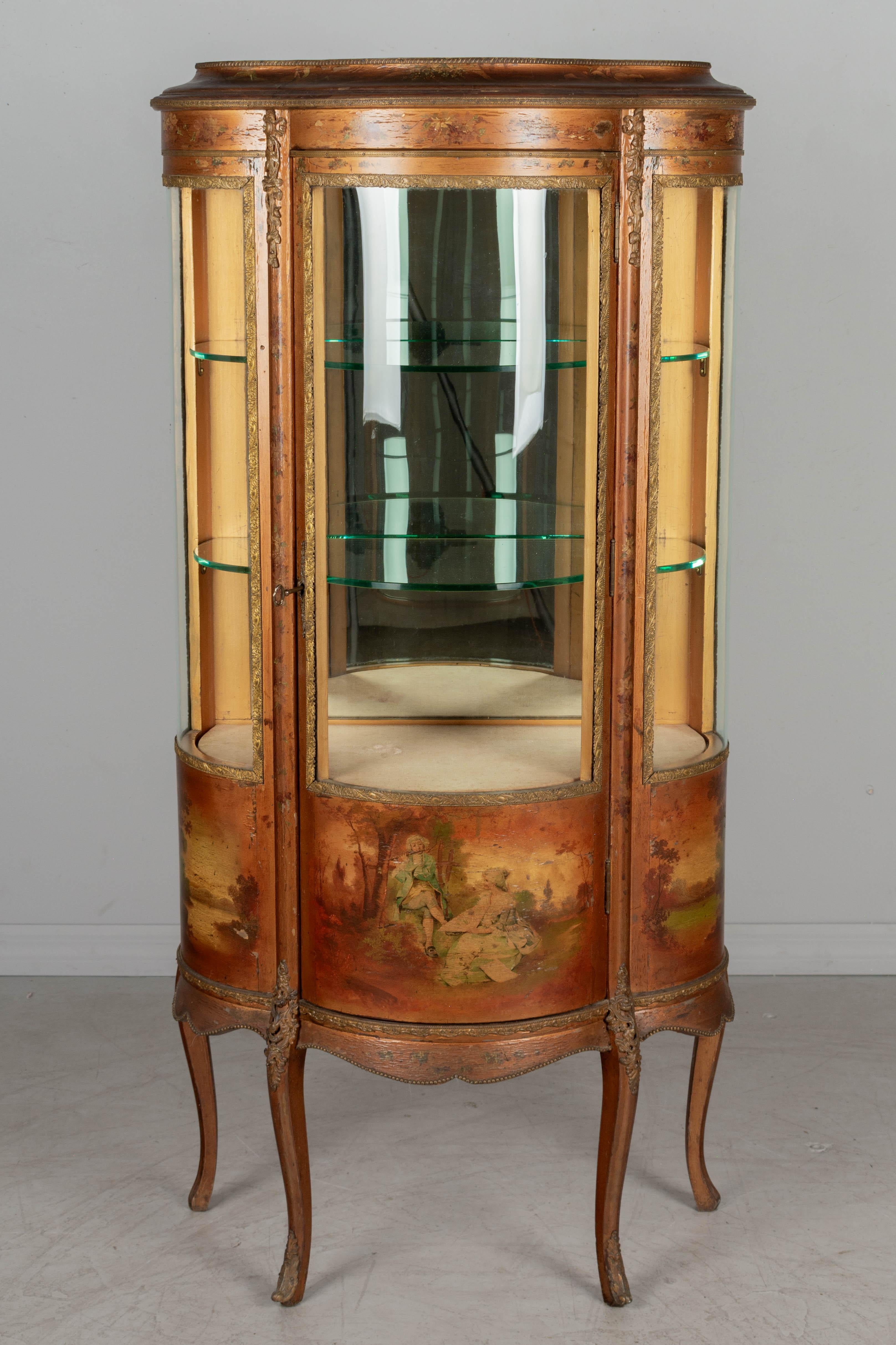 A 19th century French Louis XIV style Vernis Martin vitrine with hand painted panels, cast bronze mounts and curved glass. Raised on cabriole legs with foliate cast brass trim throughout. Giltwood construction with single door opening to interior
