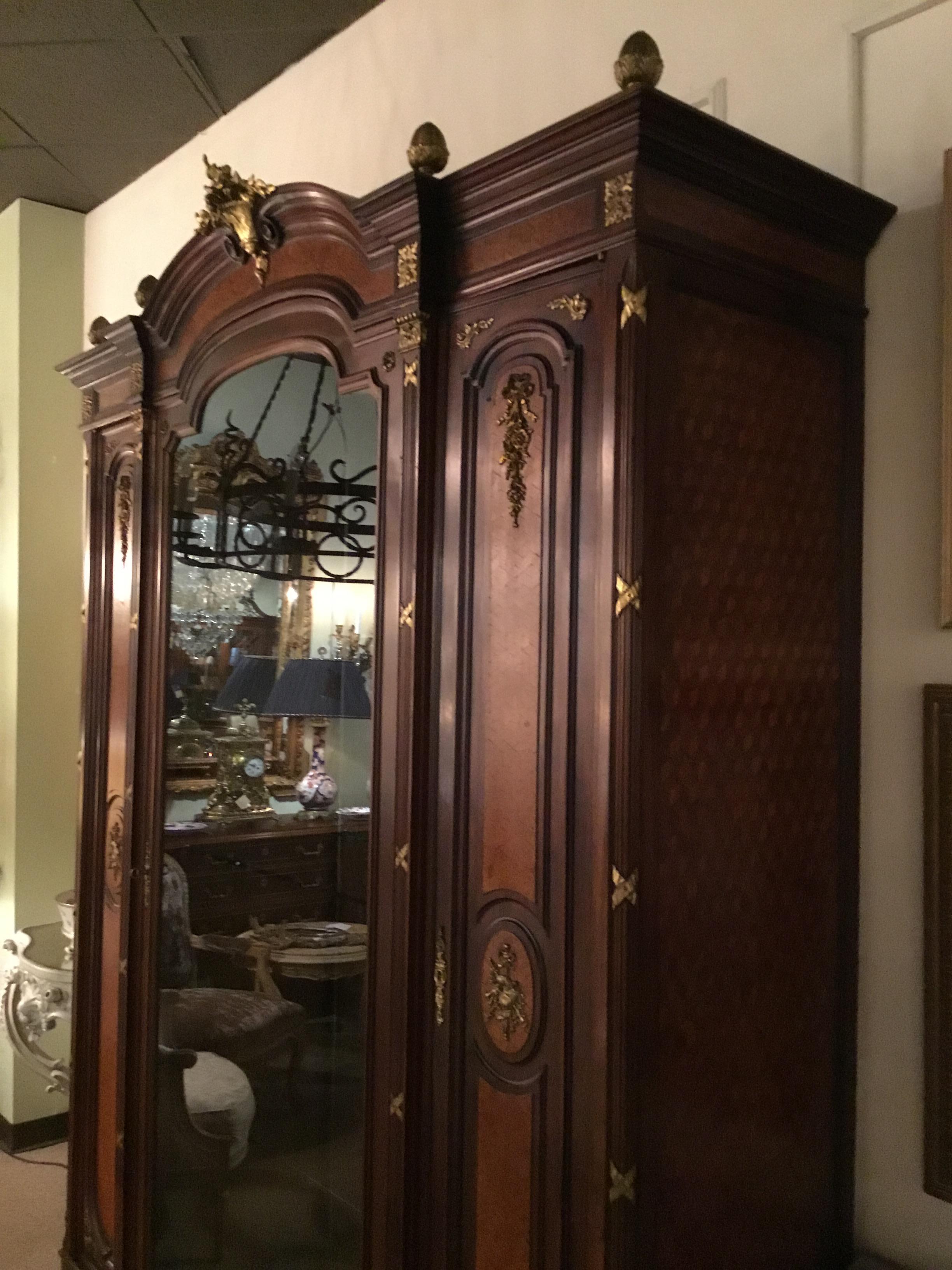 Exceptional display cabinet with center opening door to fitted interior with three glass shelves
that are moveable. It has a mirror back and mirror on the bottom. Two doors open on each
side for storage that are fitted with four shelves each. Gilt