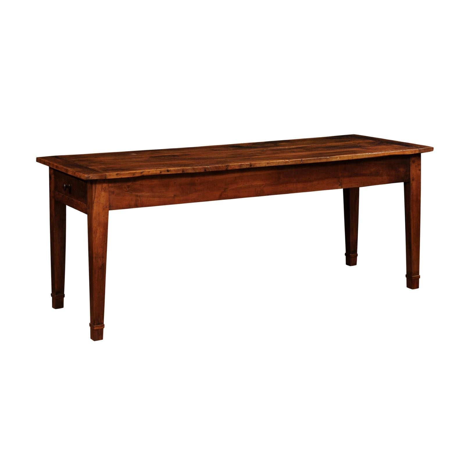 A French Louis XVI style walnut and elm table from the 19th century, with single lateral drawer, tapered legs and great rustic character. Created in France during the 19th century, this walnut and elm table charms us with its rustic presence and