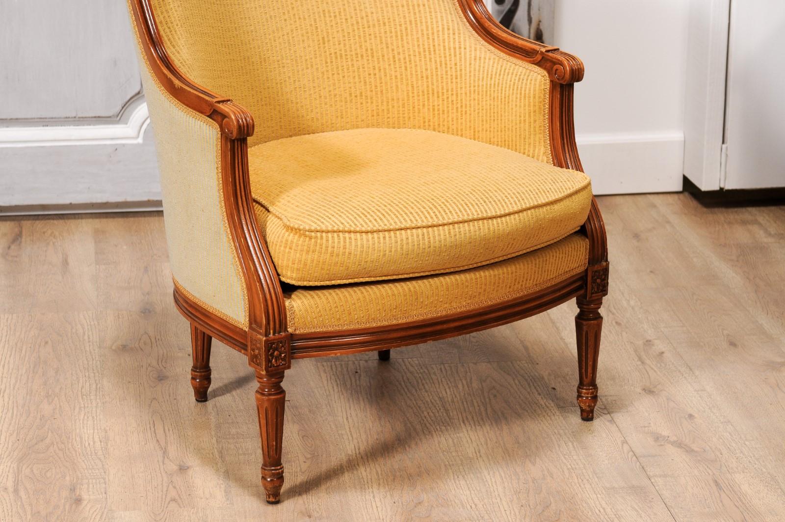 Carved French Louis XVI Style Walnut Bergères Chairs with Wraparound Backs, Pair For Sale