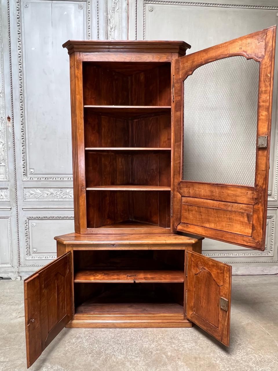 A French Louis XVI style country French walnut corner cabinet with chicken wire in the door. This beautiful cabinet as a wondeful patina and is probably late 18th century rather than mid 19th as listed. It was more than likely built in so it appears