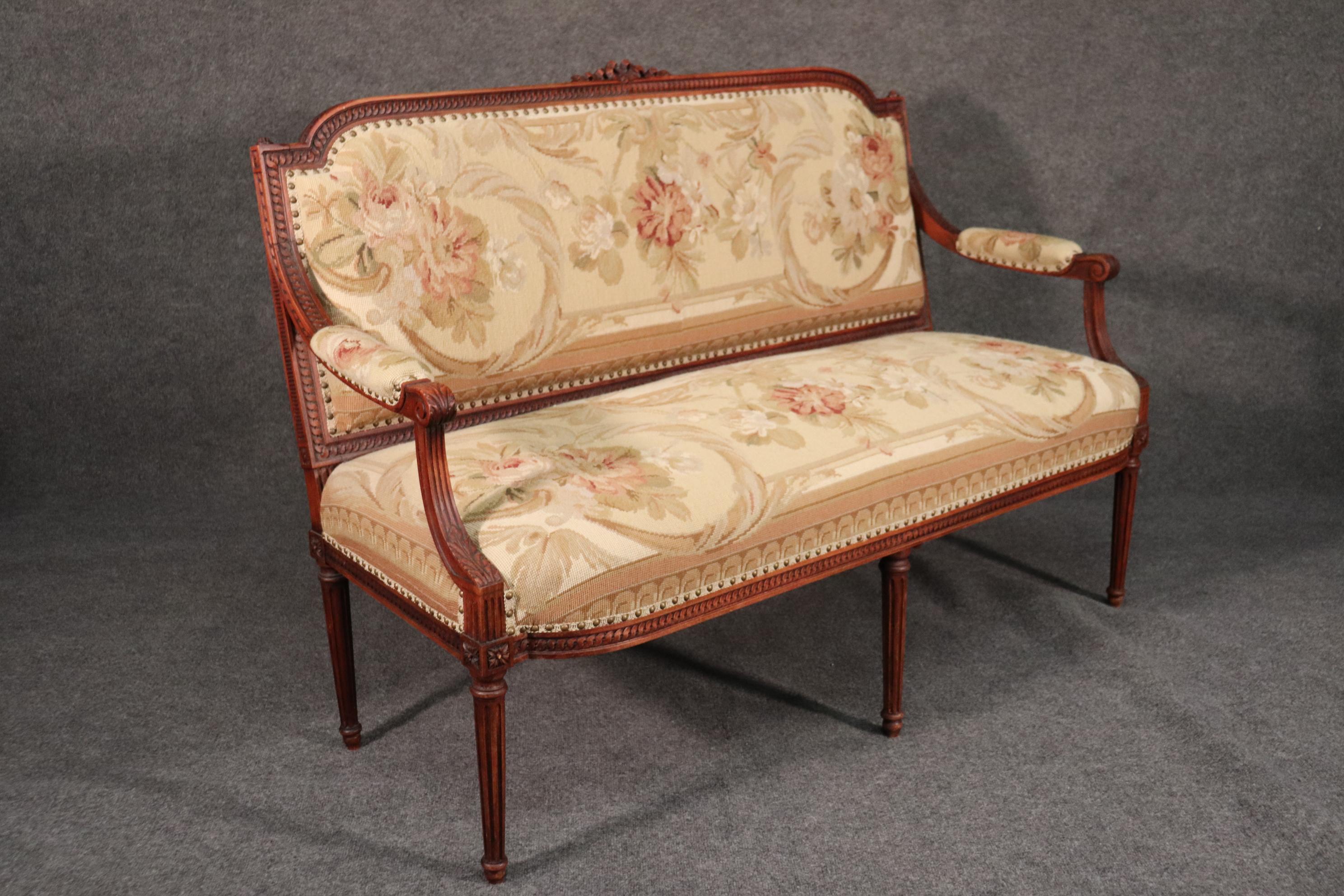 This is a fantastic settee that is beautifully carved and in very good antique condition. The settee features a tapestry upholstery and the tapestry is in good condition as well. This is used but in good condition for its age. Expect some