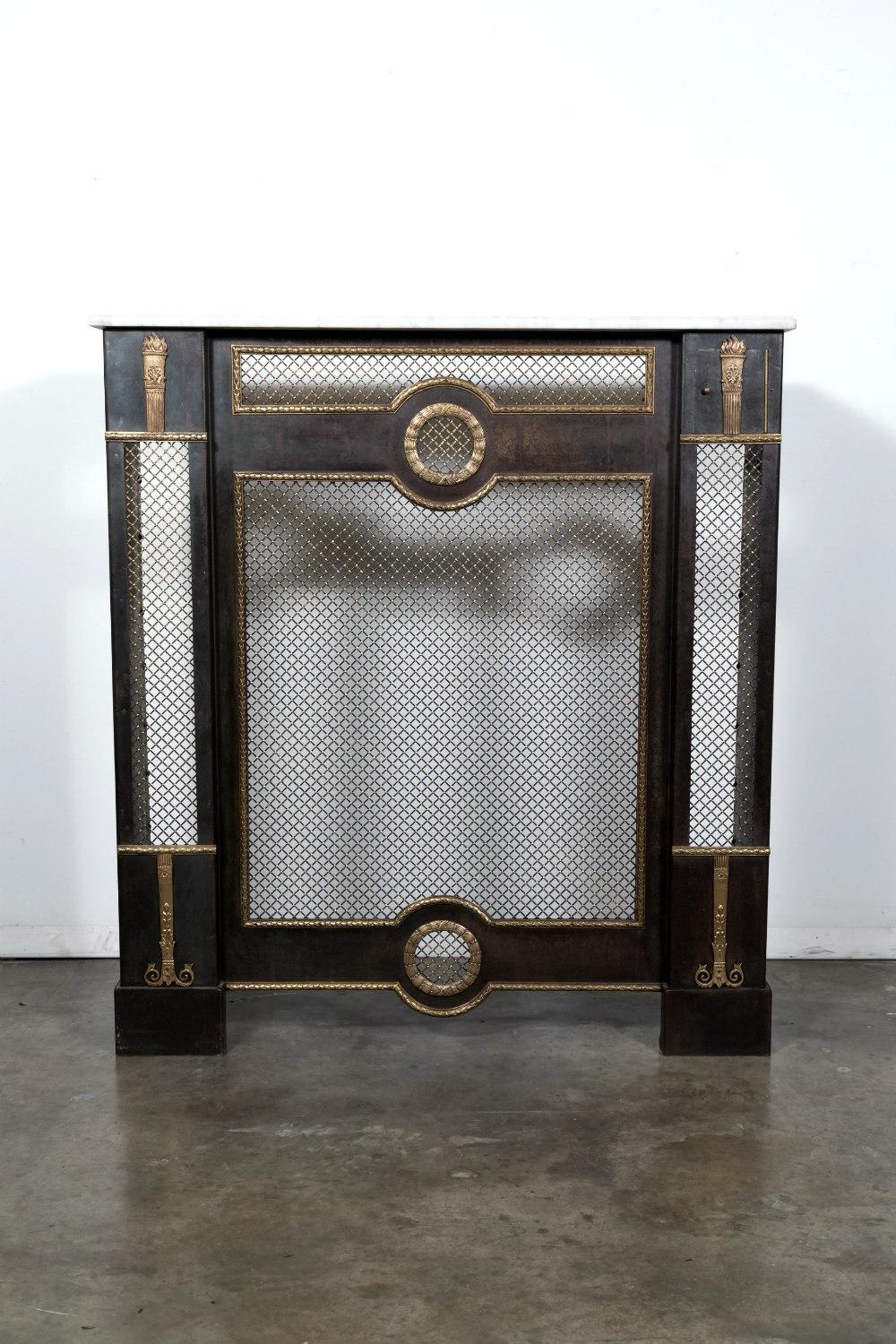 Rare French Louis XVI style wrought iron radiator cover with a white Carrara marble top, having mahogany panels with fruitwood inlays on each side. This handsome cache radiateur was made in Paris during the 1930s and features heavy brass wire and