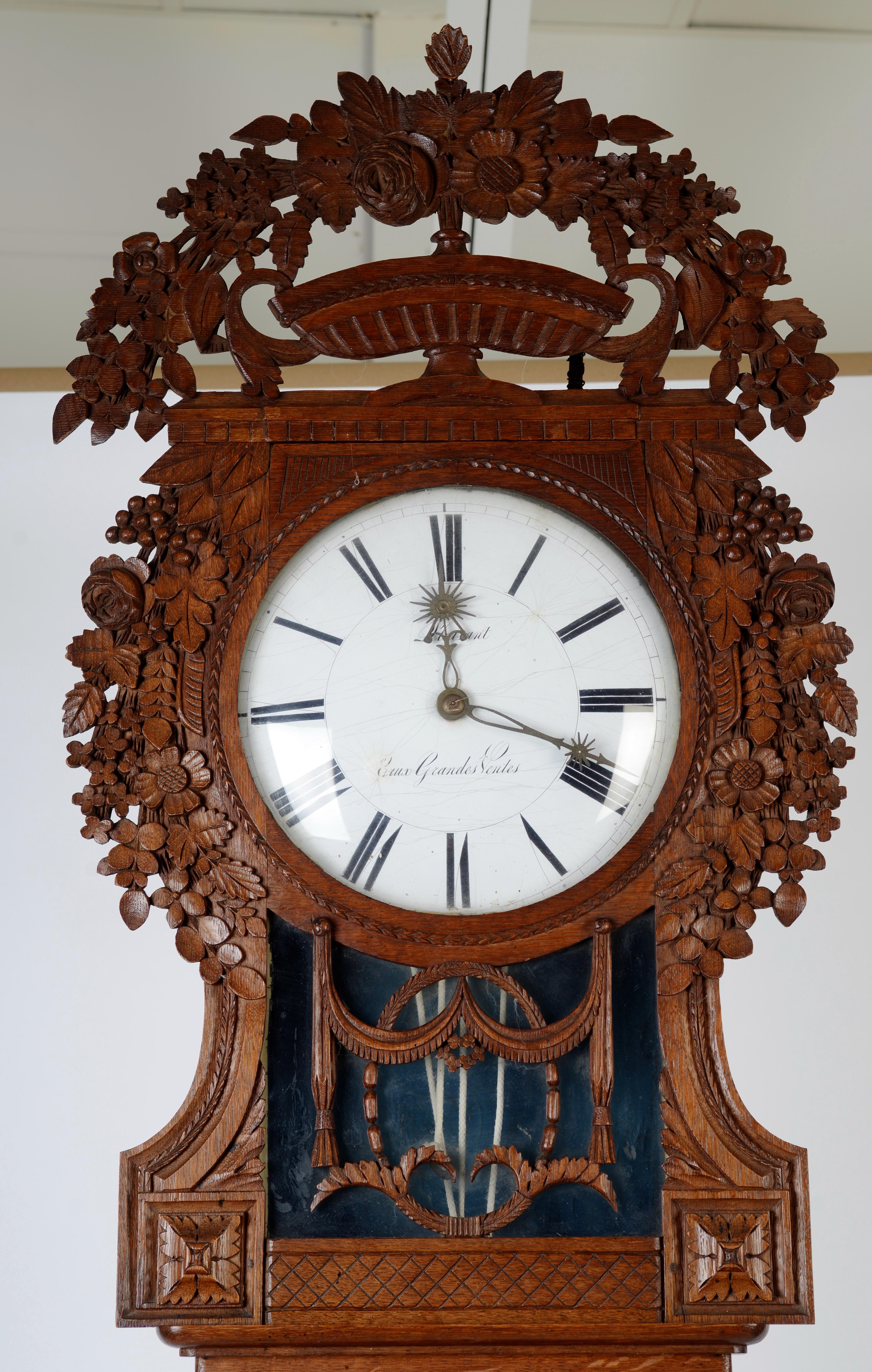 French Louis XVI tall case clock, c1800. They also are referred to as “St Nicolas-Clock” because they were made around the village Saint Nicolas d'Aliermont in Normandy. The oak case id beautifully carved with flowers and swags. The clock is running