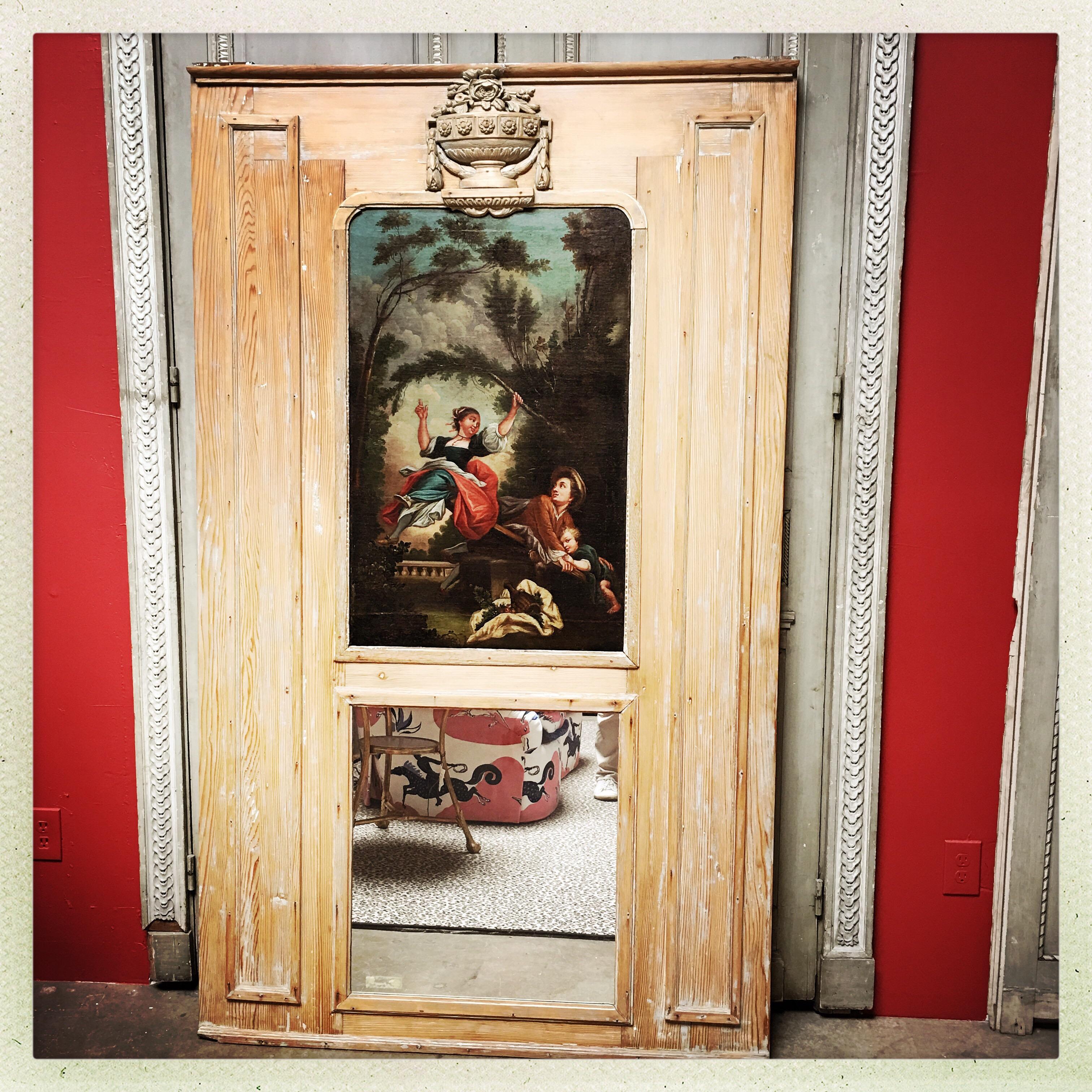 A French striped pine trumeau mirror with an oil painting in the style of Fragonard.