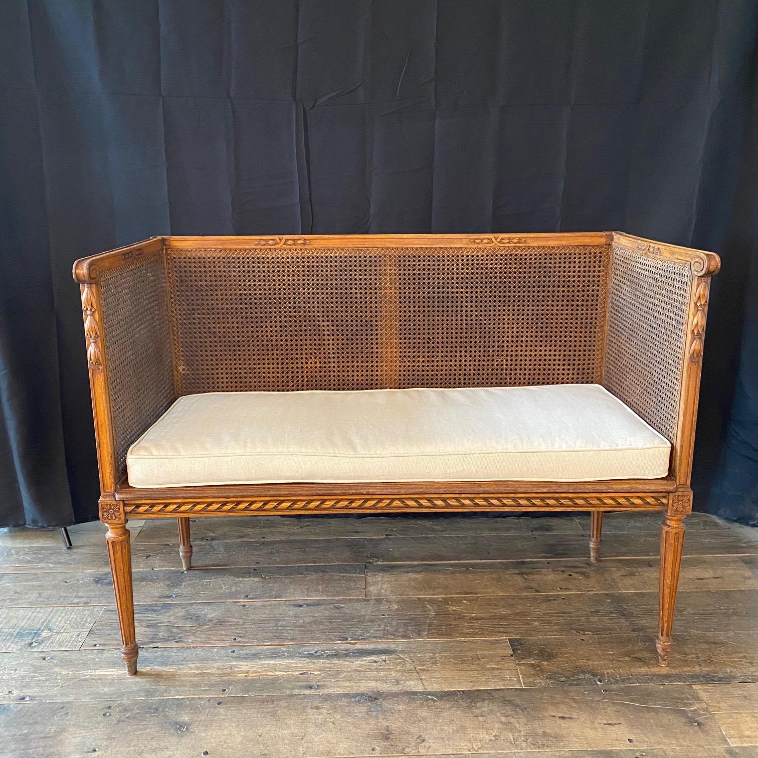 Fantastic, original and rare loveseat made in France in the early 1900s with double caning in the style of Louis XVI. A few minor breaks in the caning on the back (see photos). New cushion in high end British neutral linen/cotton blend. # 6337
seat