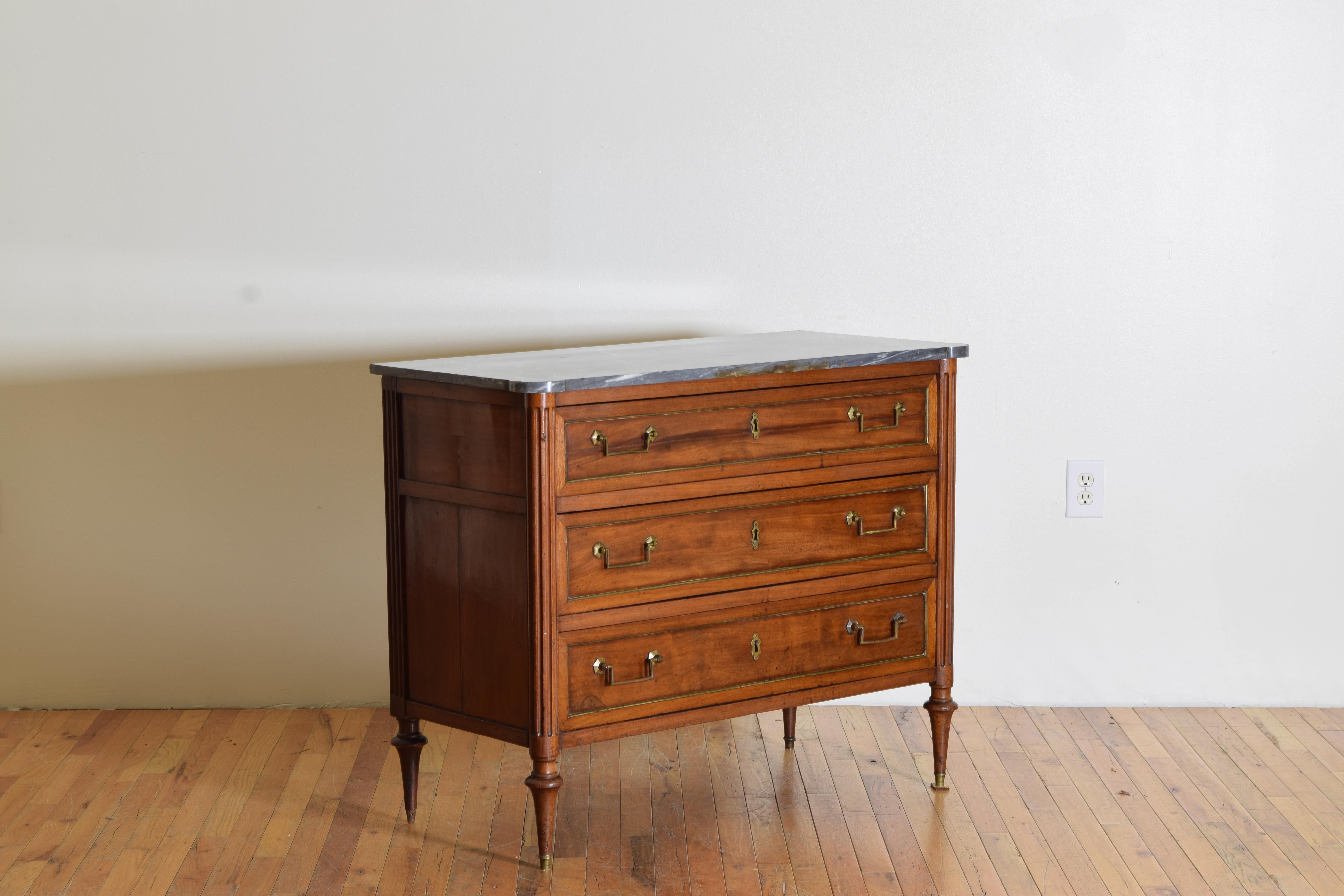 Retaining its original grey marble top of rectangular for with Roundel shaped front corners, the conforming case housing three drawers with brass moldings, the case mimicking the tops with fluted Roundel corners, appearing to retain original