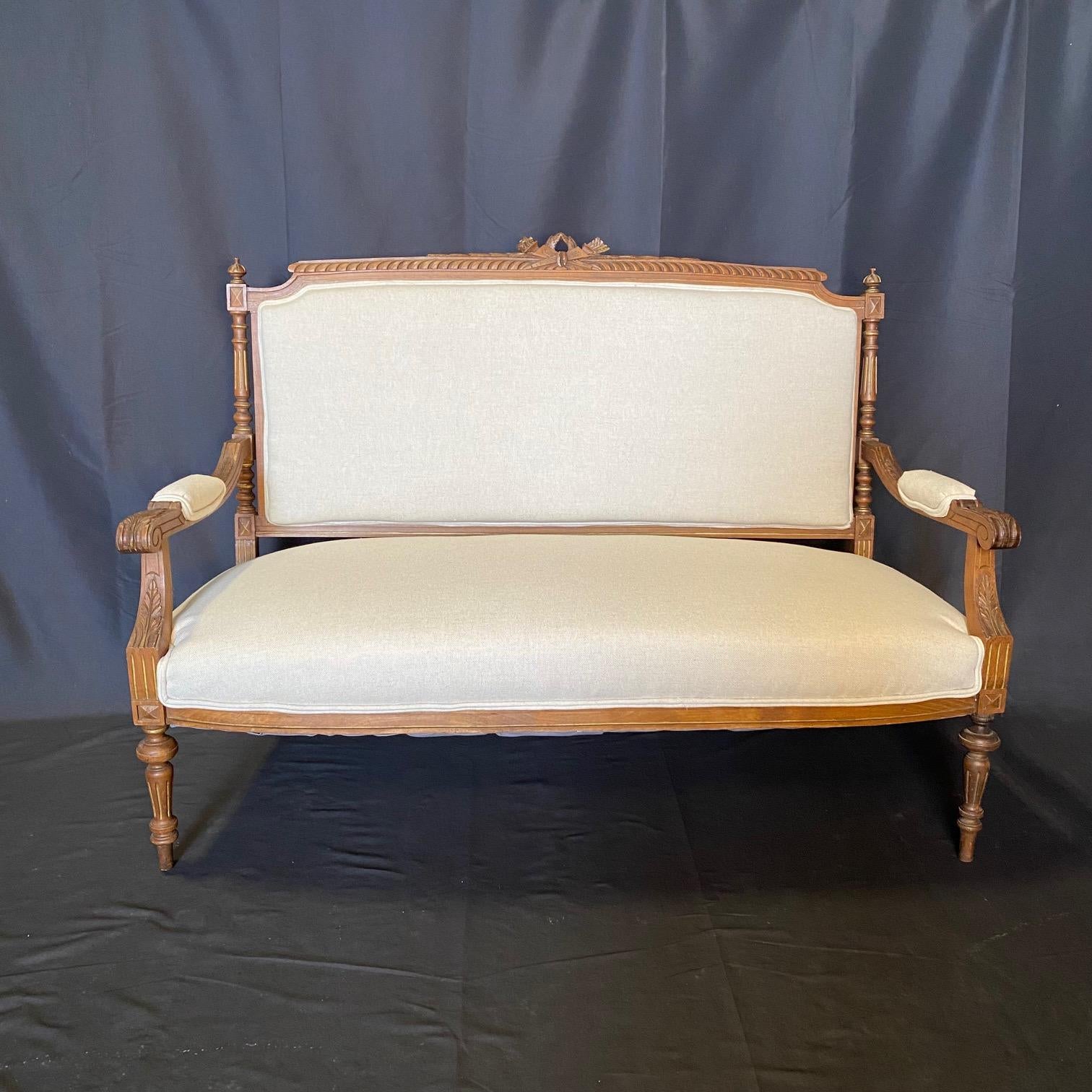 Un élégant et grand ensemble de salon composé d'un canapé, d'une causeuse ou d'un canapé et de deux chaises d'appoint, chacun finement détaillé avec une traverse de crête centrée sur une branche de baies enrubannée et une couronne pendante au-dessus