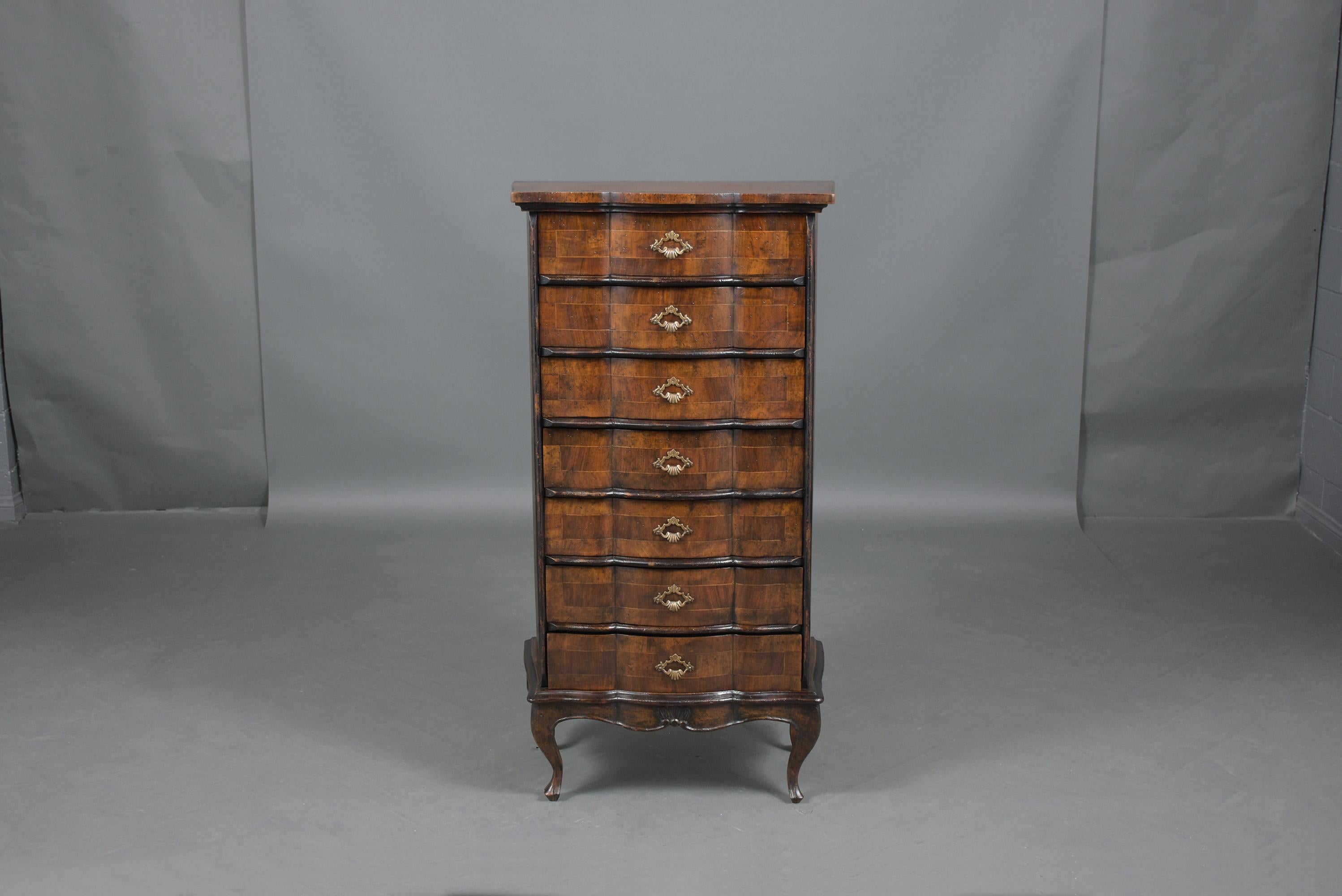 An extraordinary tall chest of drawers hand-crafted out of walnut wood and is professionally restored by our craftsmen. This fabulous cabinet features dark walnut color ebonized moldings, a beautiful patina finish, and seven drawers each is covered
