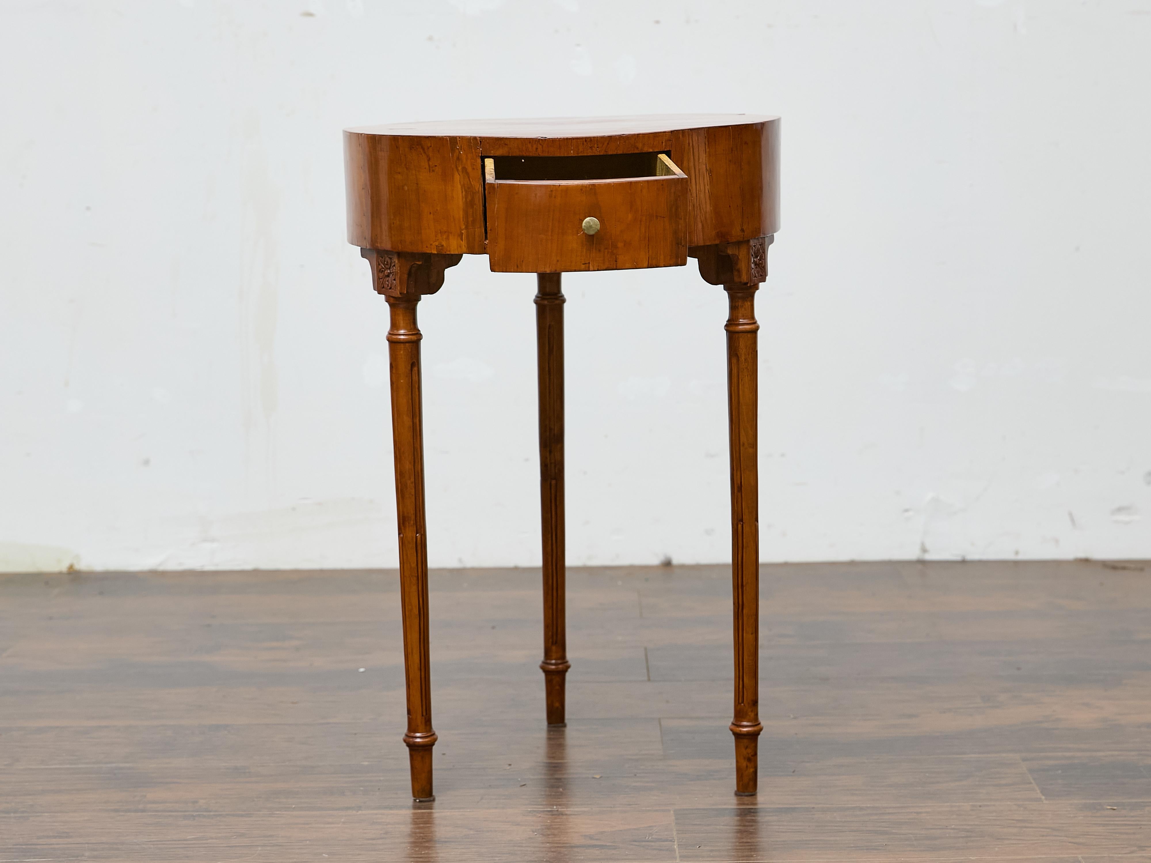 Crafted in France during the late 18th century, this Louis XVI walnut side table presents a refined neoclassical silhouette ideal for a variety of interiors. The circular top is constructed with beautifully figured walnut and features a sunburst