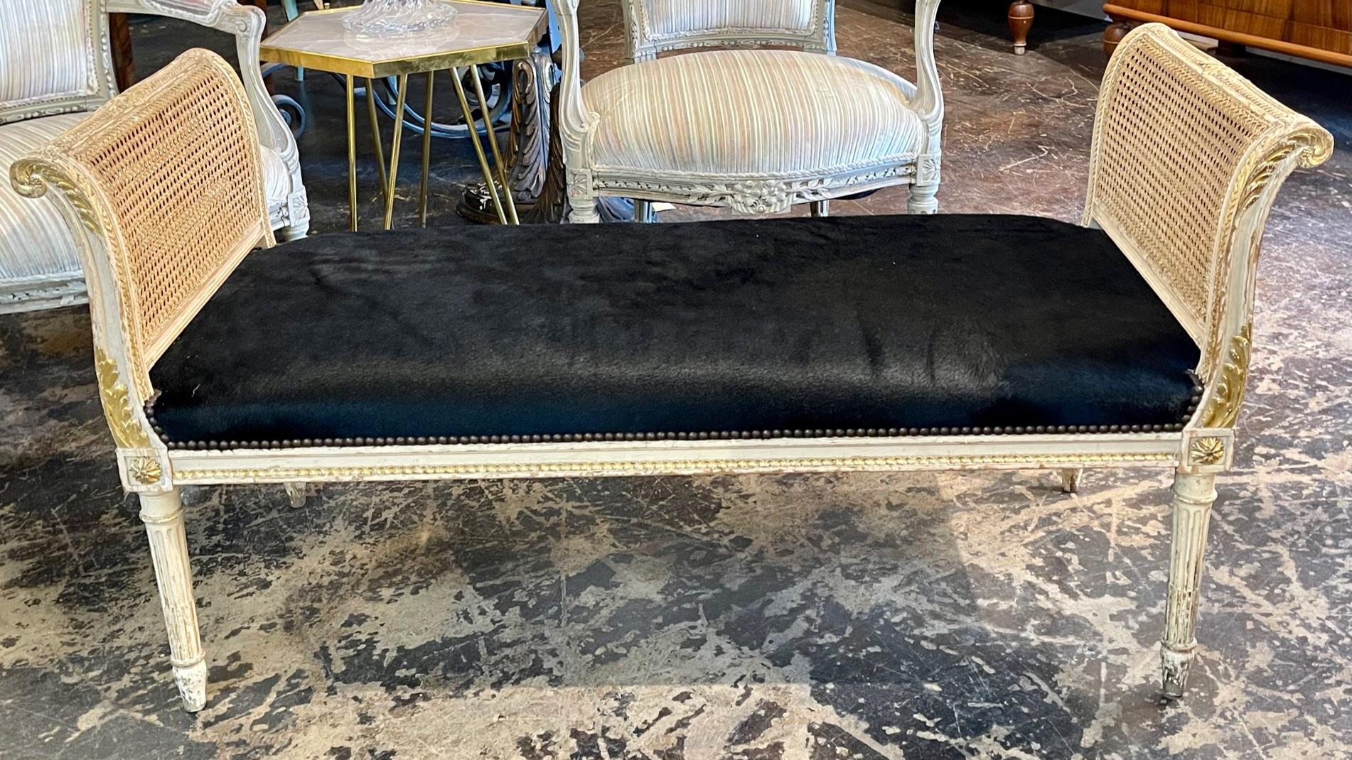 19th century French Louis XVI style carved and parcel gilt window bench with black cowhide. Circa 1870. Adds warmth and charm to any room.